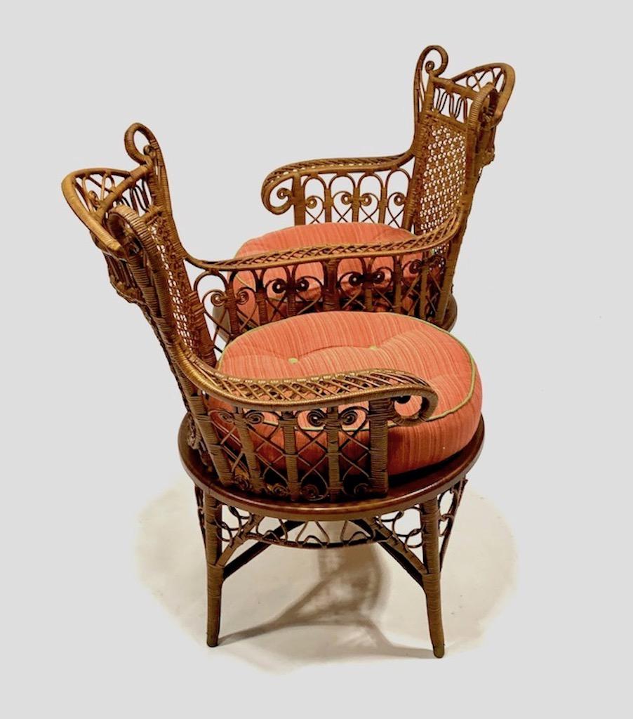 A very rare wicker conversation chair also known as a Tete-a-Tete .This side by side chair is woven in a very gracious design in a natural finish with beautifully styled curly cue wing sided head rests which sit above intricately hand caned backs.