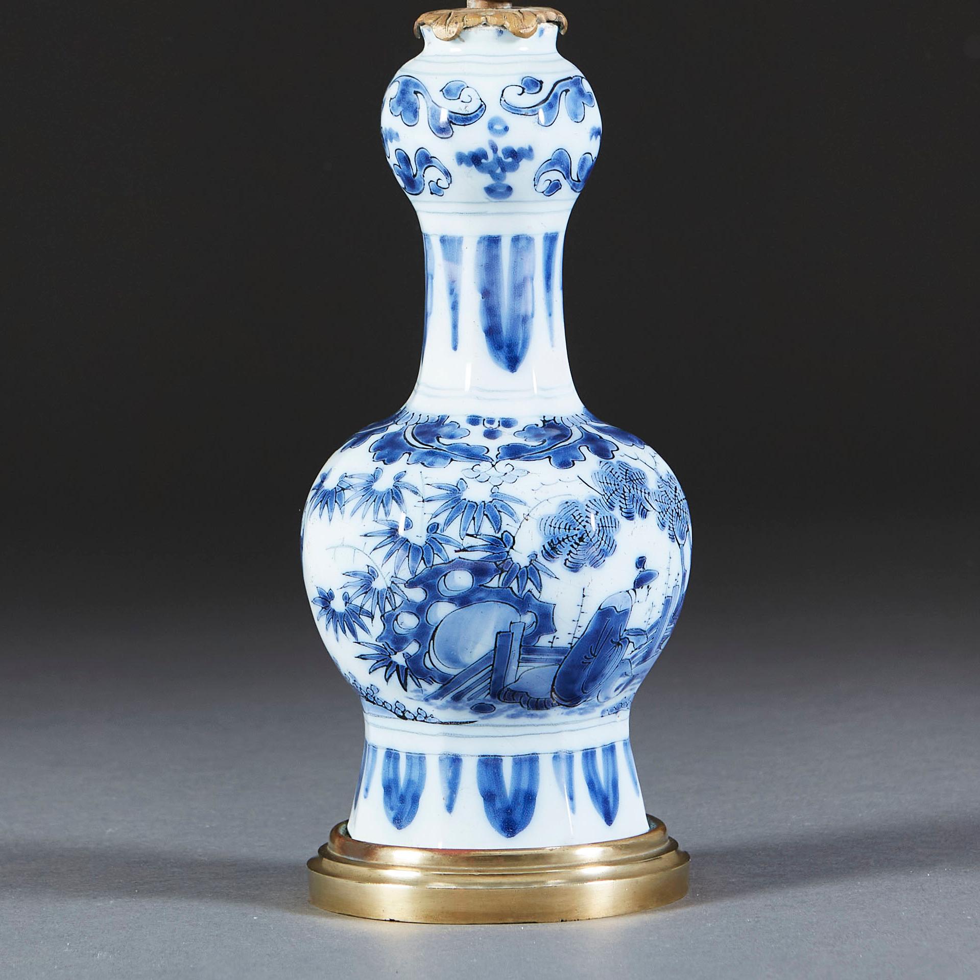 A mid nineteenth century blue and white Delft lamp decorated with oriental scenes and floral motifs, mounted on a brass base and converted as a table lamp.

Please note: lampshade not included.

Currently wired for the UK.