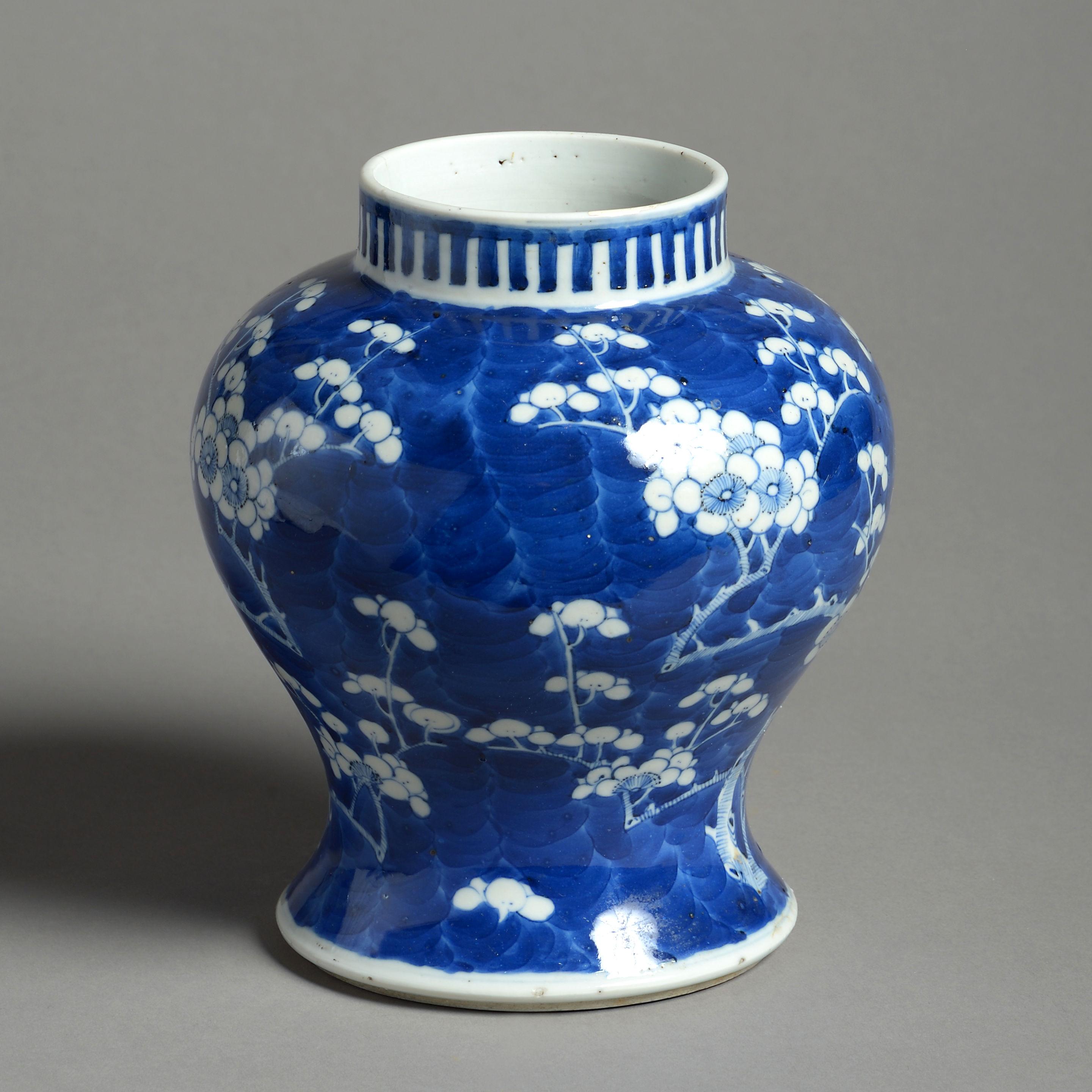 A mid-19th century porcelain baluster vase, decorated throughout with white prunus blossom upon a blue ground in the Kangxi manner. 

Having four character marks to the underside. A hairline to the rim.