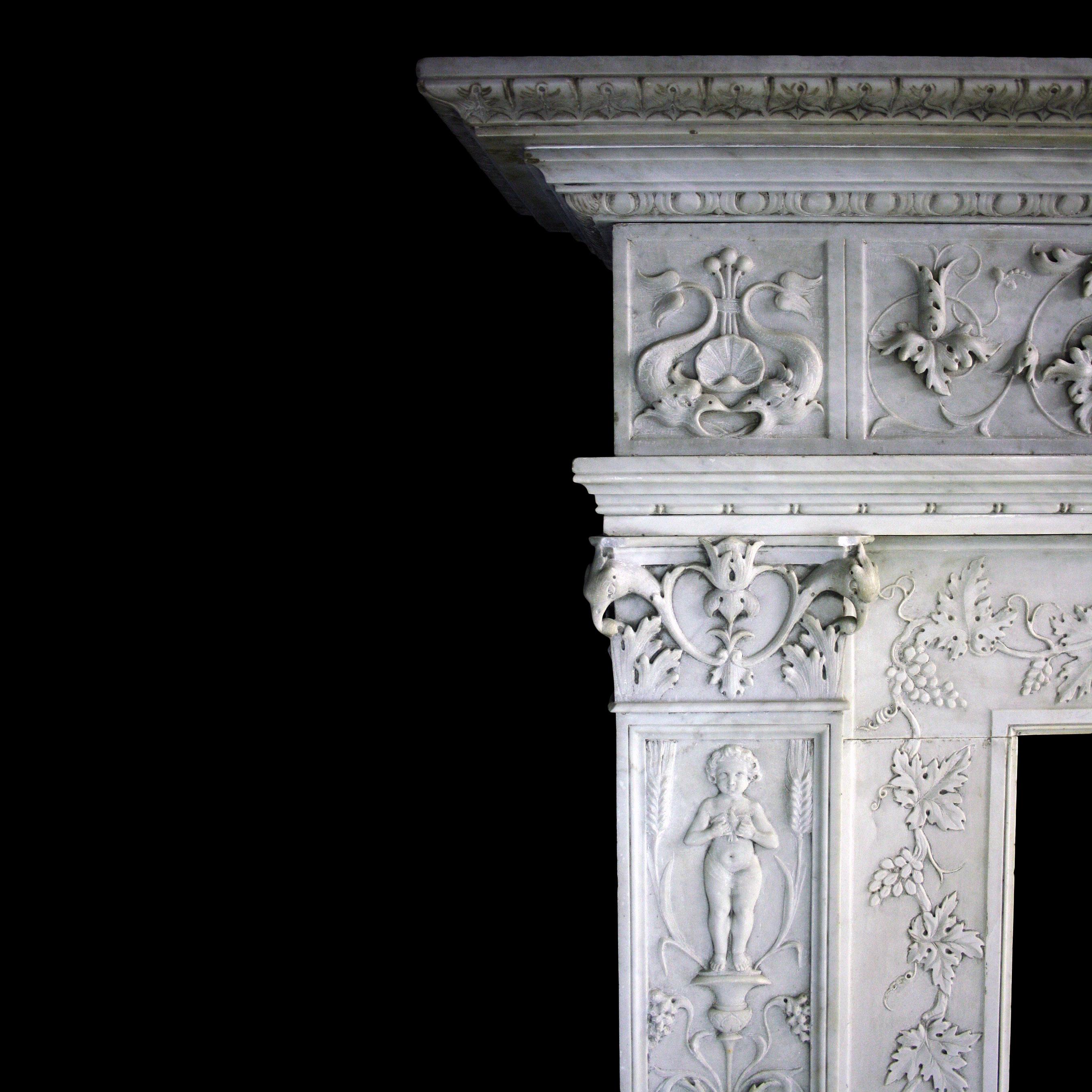 Ein Kamin aus geschnitztem Carrara-Marmor aus dem 19. Jahrhundert im Stil der Renaissance. Es hat gestufte, profilierte Fußblöcke unter reich verzierten Pfosten mit korinthischen Kapitellen. Der Boden besteht aus verschlungenen Weinreben und