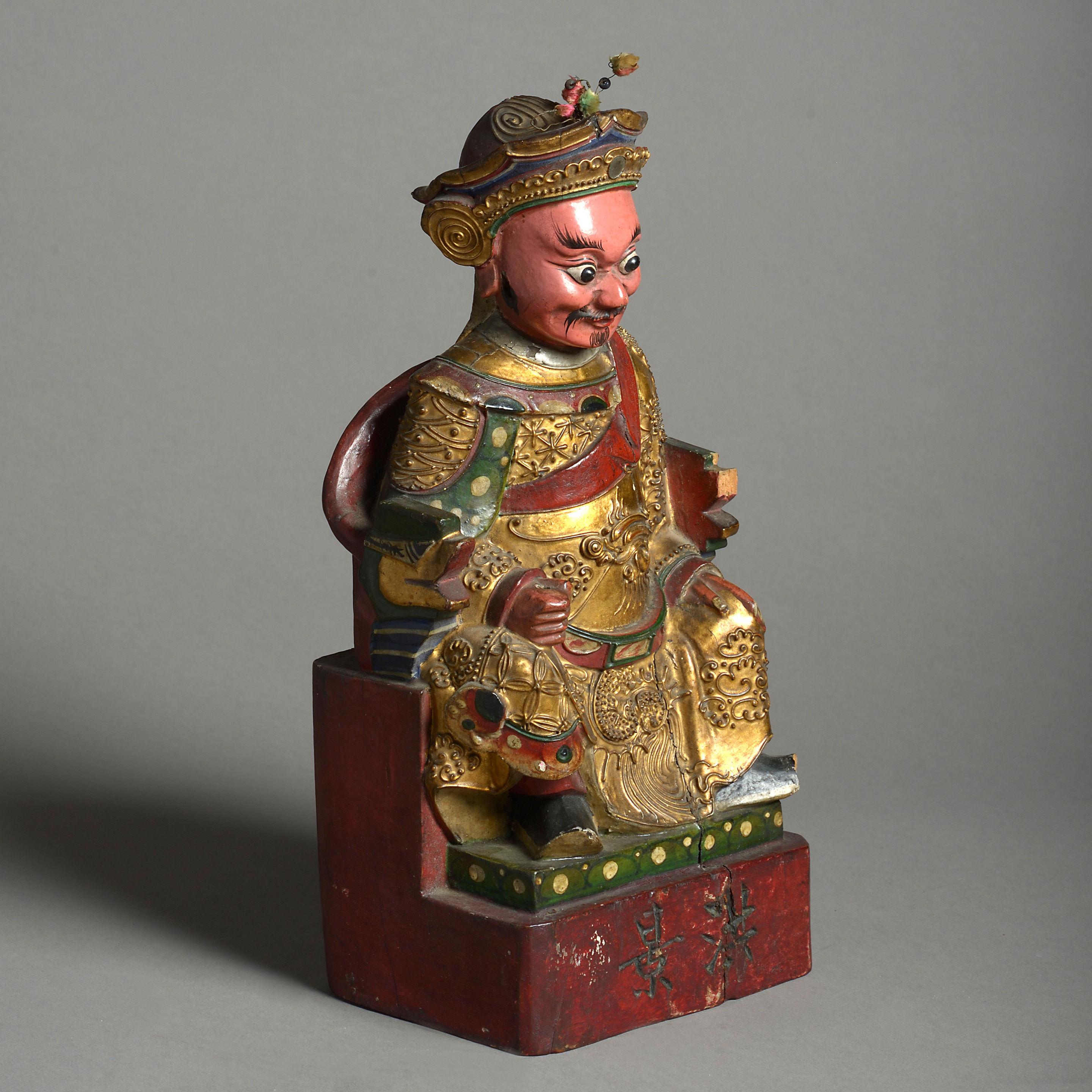 A mid-19th century finely carved, painted and gilded seated Chinese deity.