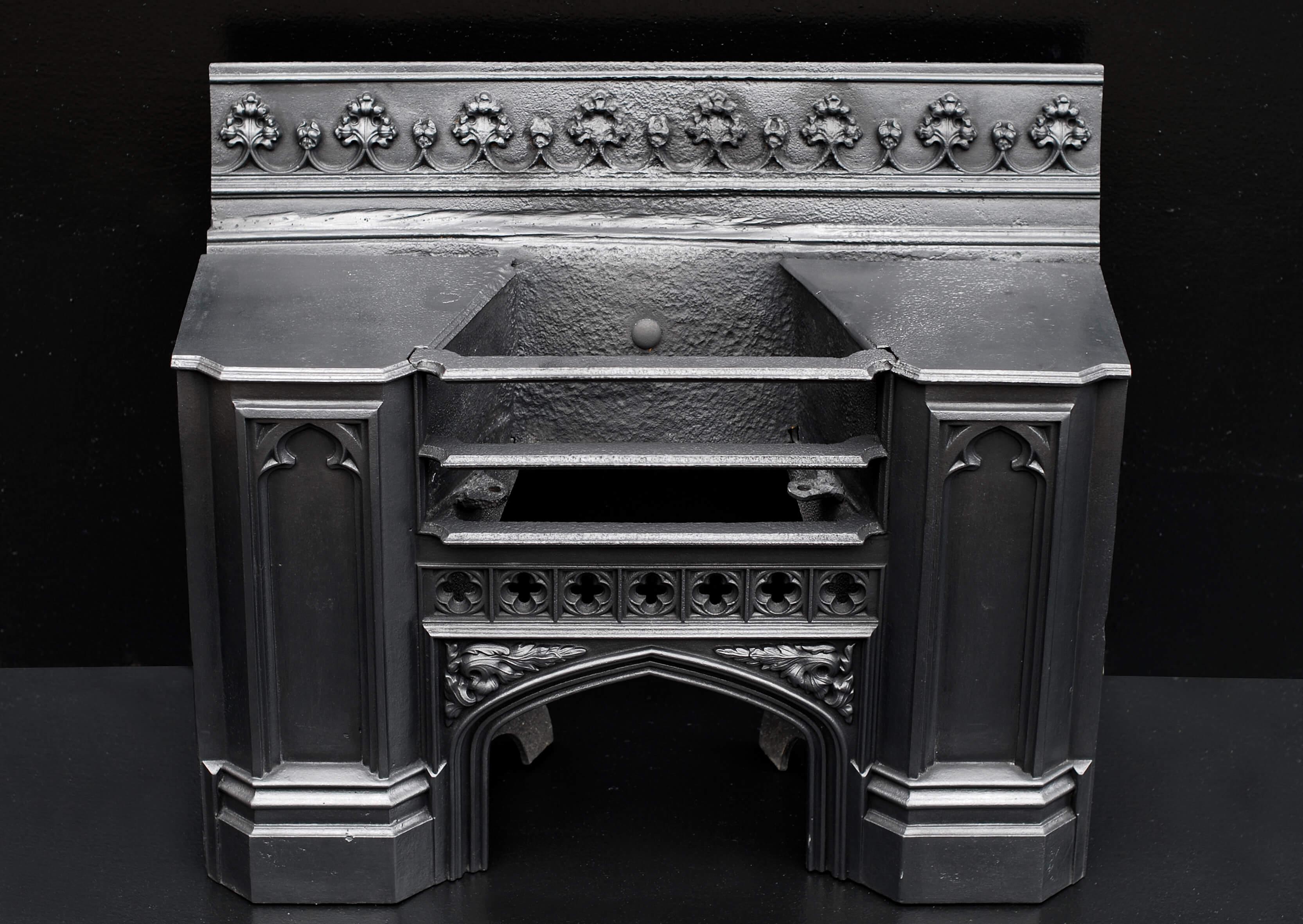 A 19th century cast iron hob grate in the Gothic style. The burning area with rosette pattern and cast spandrels below. Decorative wreath motif to back. English, 19th century.

Width At Front:	715 mm      	28 ⅛