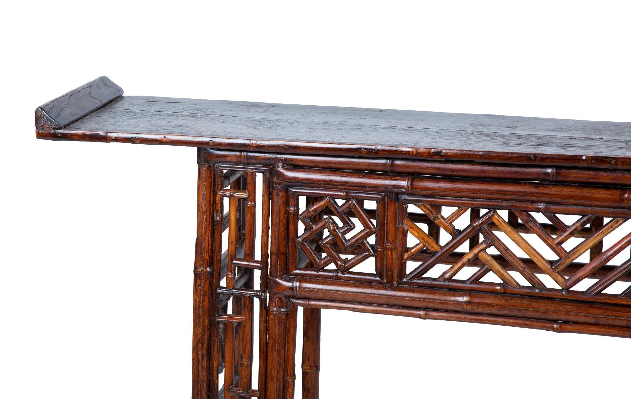 Chinese Chippendale style console with a black lacquer top over a tortoise shell decorated bamboo frame having Chippendale designs. A wonderful and rare striking piece of functional furniture.