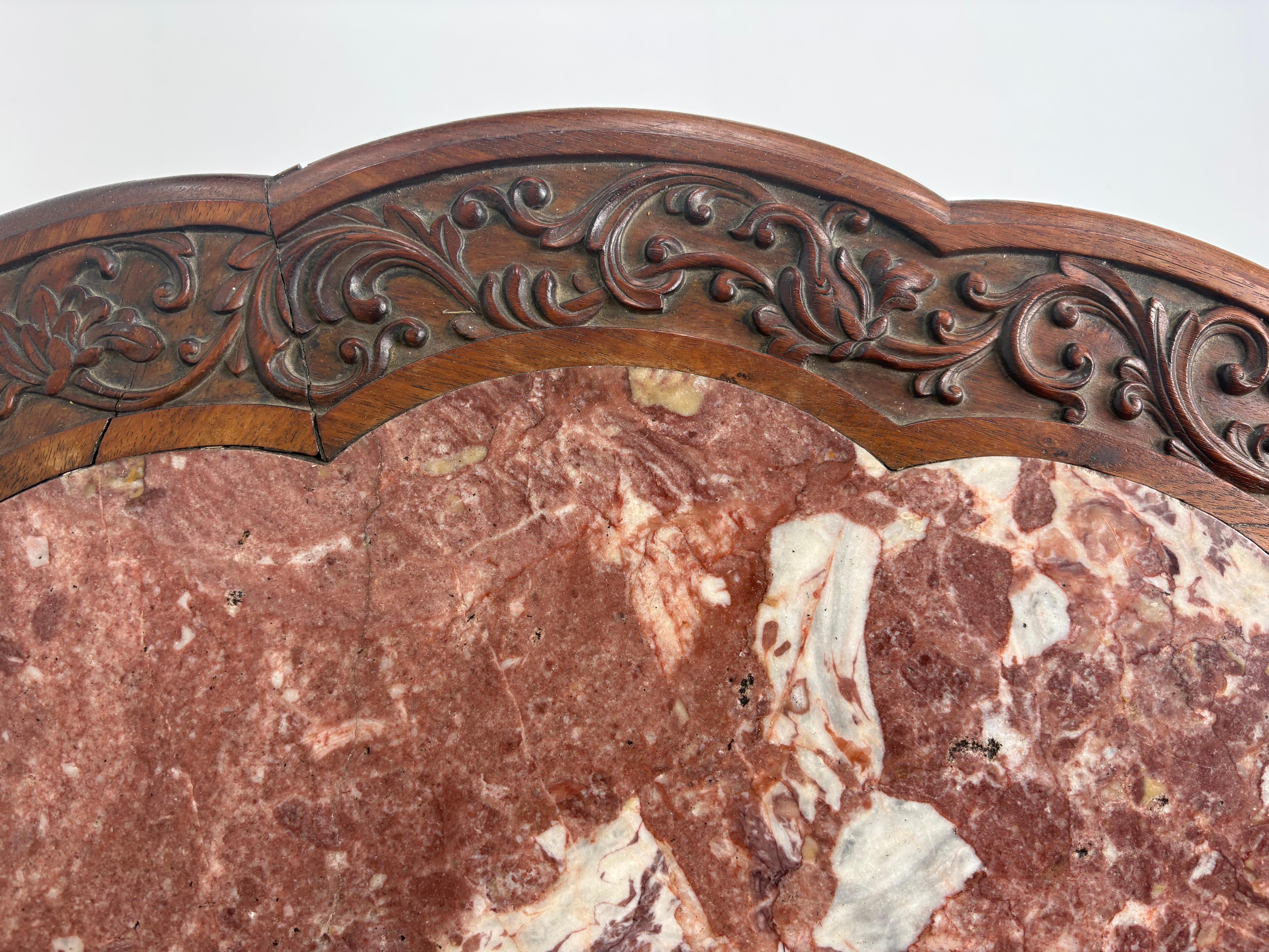Tavolo da centro cinese intagliato della metà del XIX secolo  con un intaglio eccezionale.

Il piano è circolare con un bordo foliato intagliato e smerlato e un sorprendente inserto in marmo rosa.

Una base su piedistallo intagliata, molto