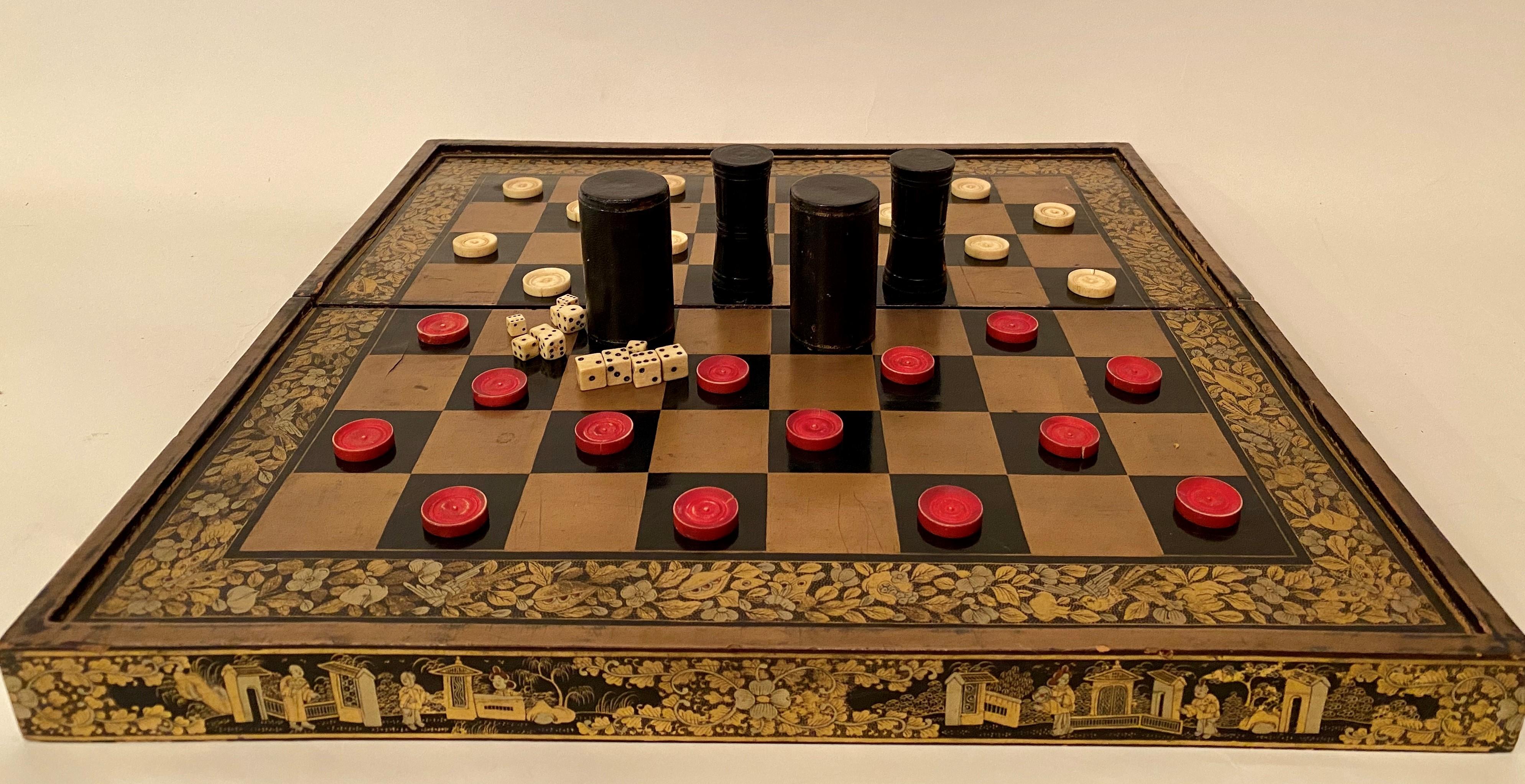 A 19th century Chinese export lacquer chess and backgammon board 50 cm x 50 cm with gold black lacquer board, with white and red counters and galloping dominoes.