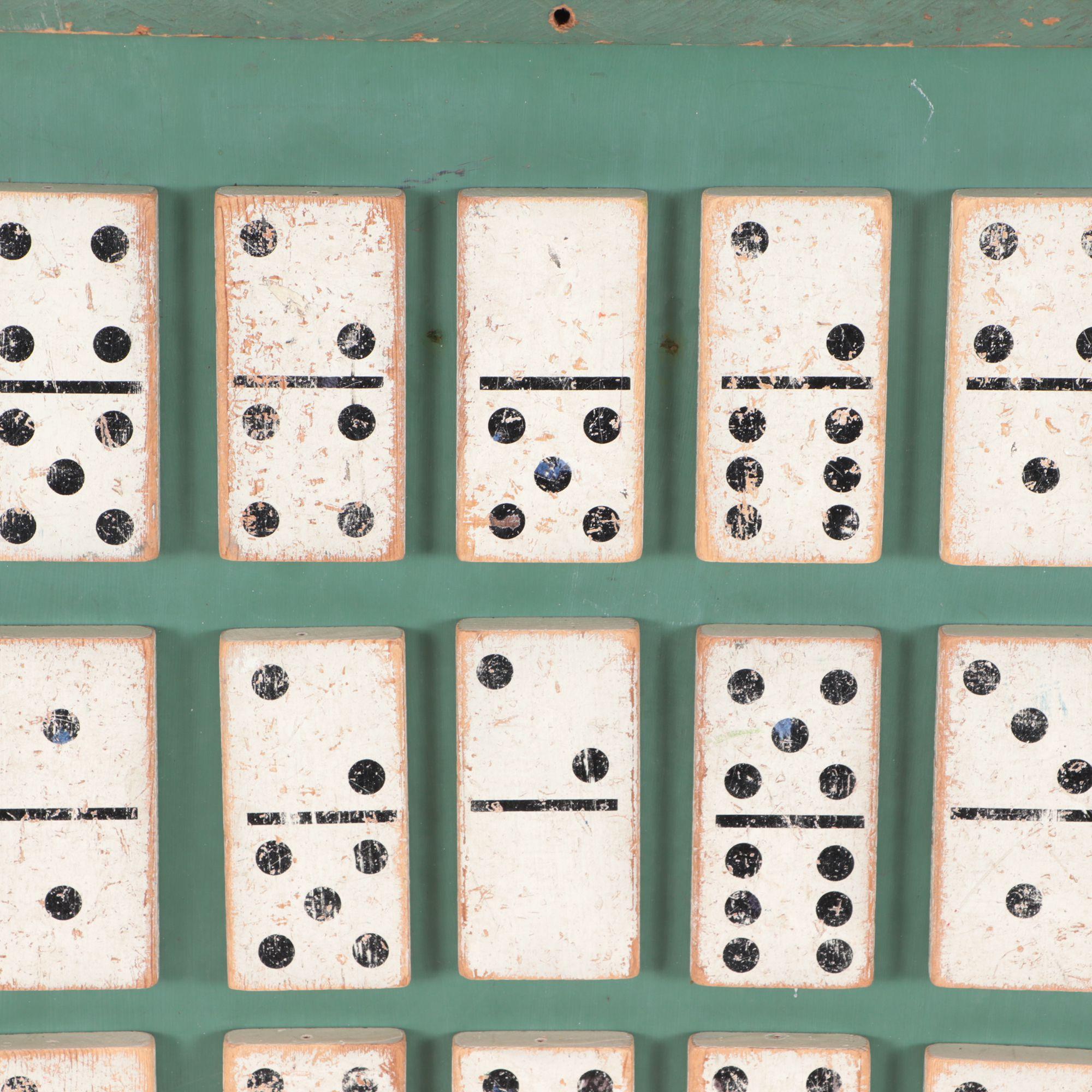 A 19th century Dominoes Folk Art Assemblage encased in a green painted wood frame.