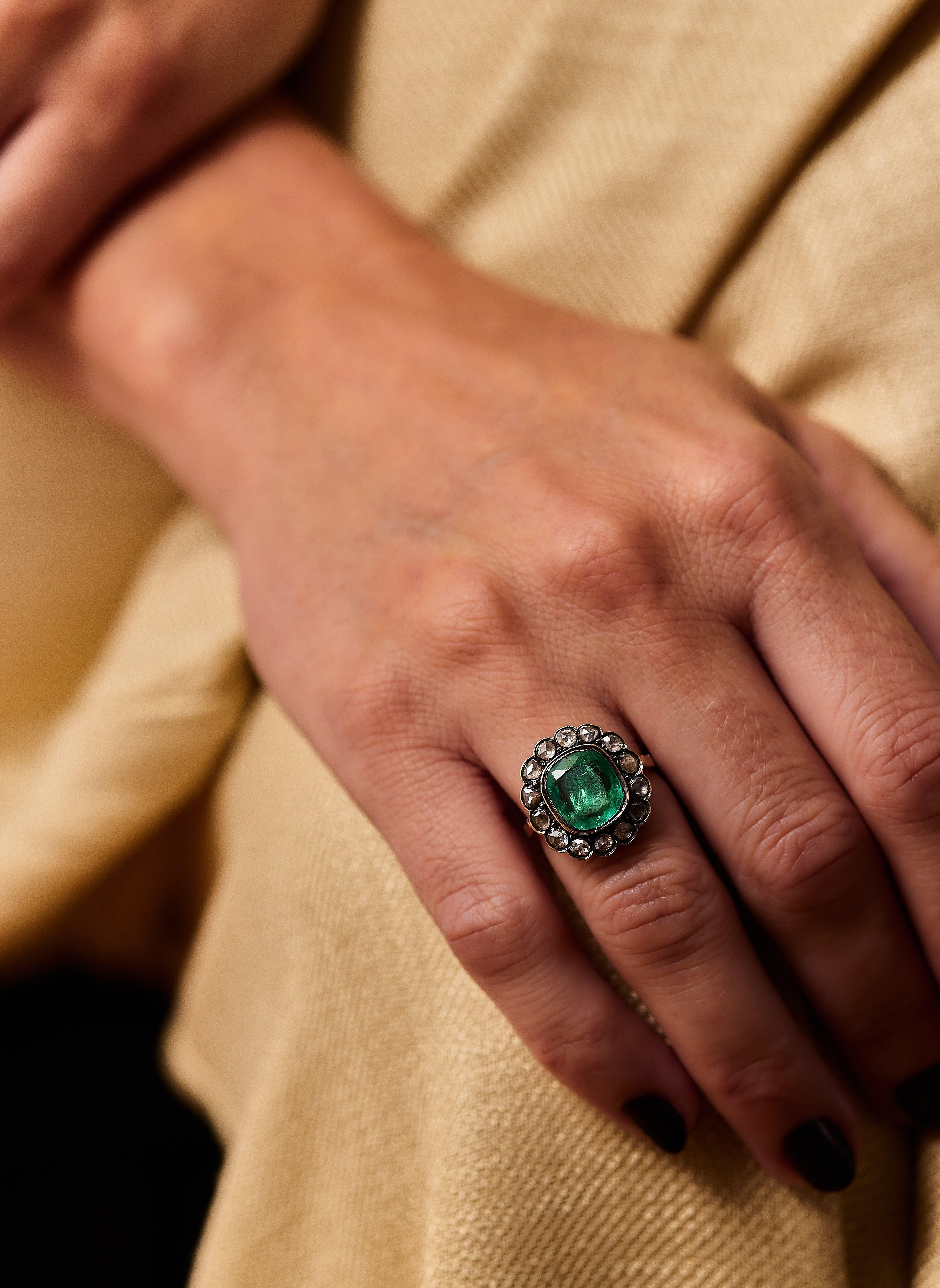 A 19th Century emerald and diamond dress ring, second half of the 19th century. 

The collet-set cushion-shaped emerald weighing approximately 2.10cts, within a closed-back rose-cut diamond surround, mounted in silver and gold, French import mark