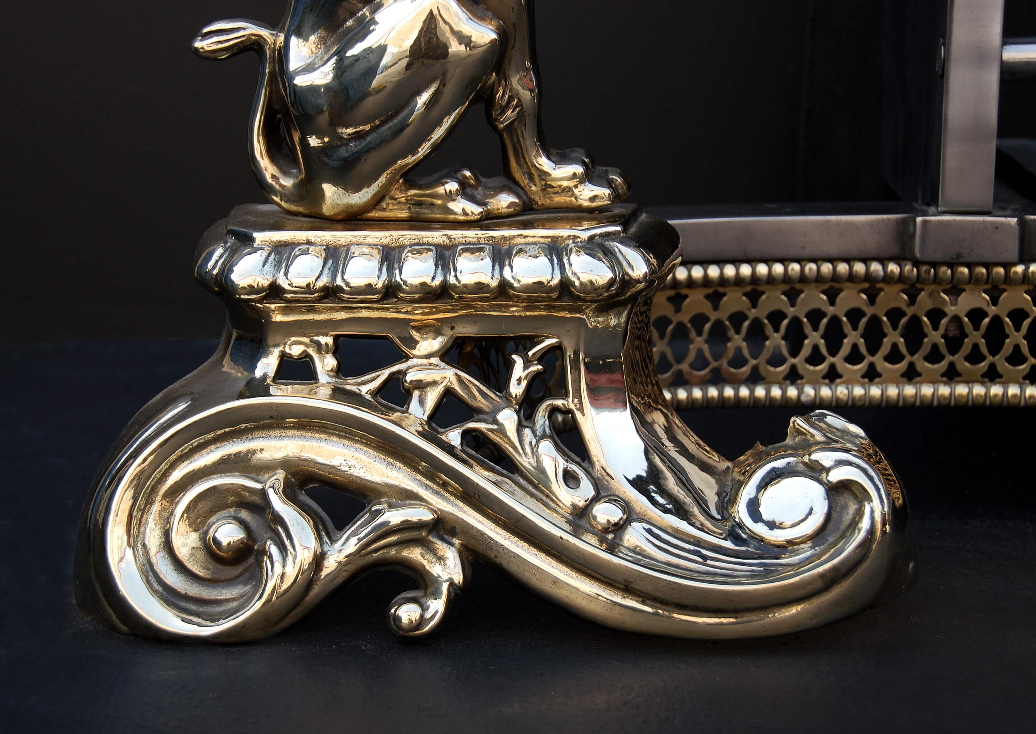 19th century English brass and steel dog-grate. The dogs with heraldic figures on scrolled feet, shaped pierced fret and ornate cast brass finials.

Measures: Width at front: 1160 mm 45 
