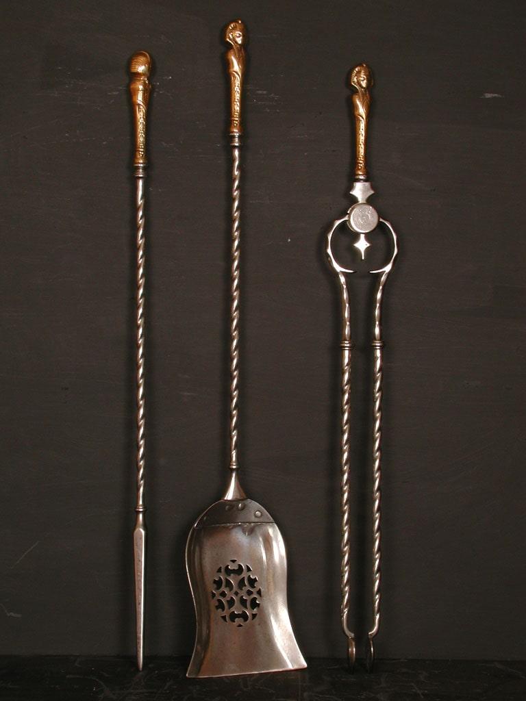 A 19th century English bronze and steel firetools, with barley twist shafts and Egyptian style handles.

Length:	810 mm      	31 ⅞