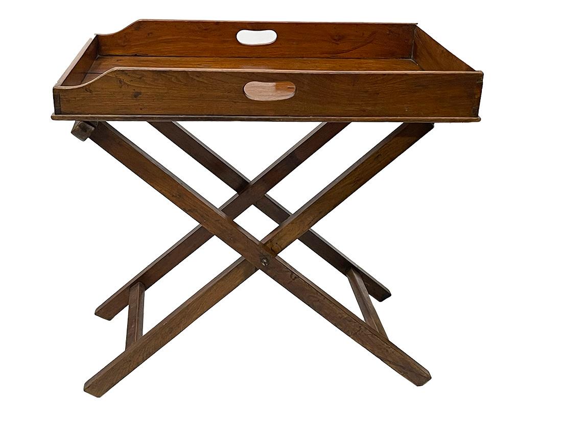 A 19th Century English butler tray on stand

A 19th Century butler tray on stand, made in England. The tray with kidney shaped open handles with raised edge of mahogany wood, lies loose on a folding x-frame with linen straps. The wood shows its age