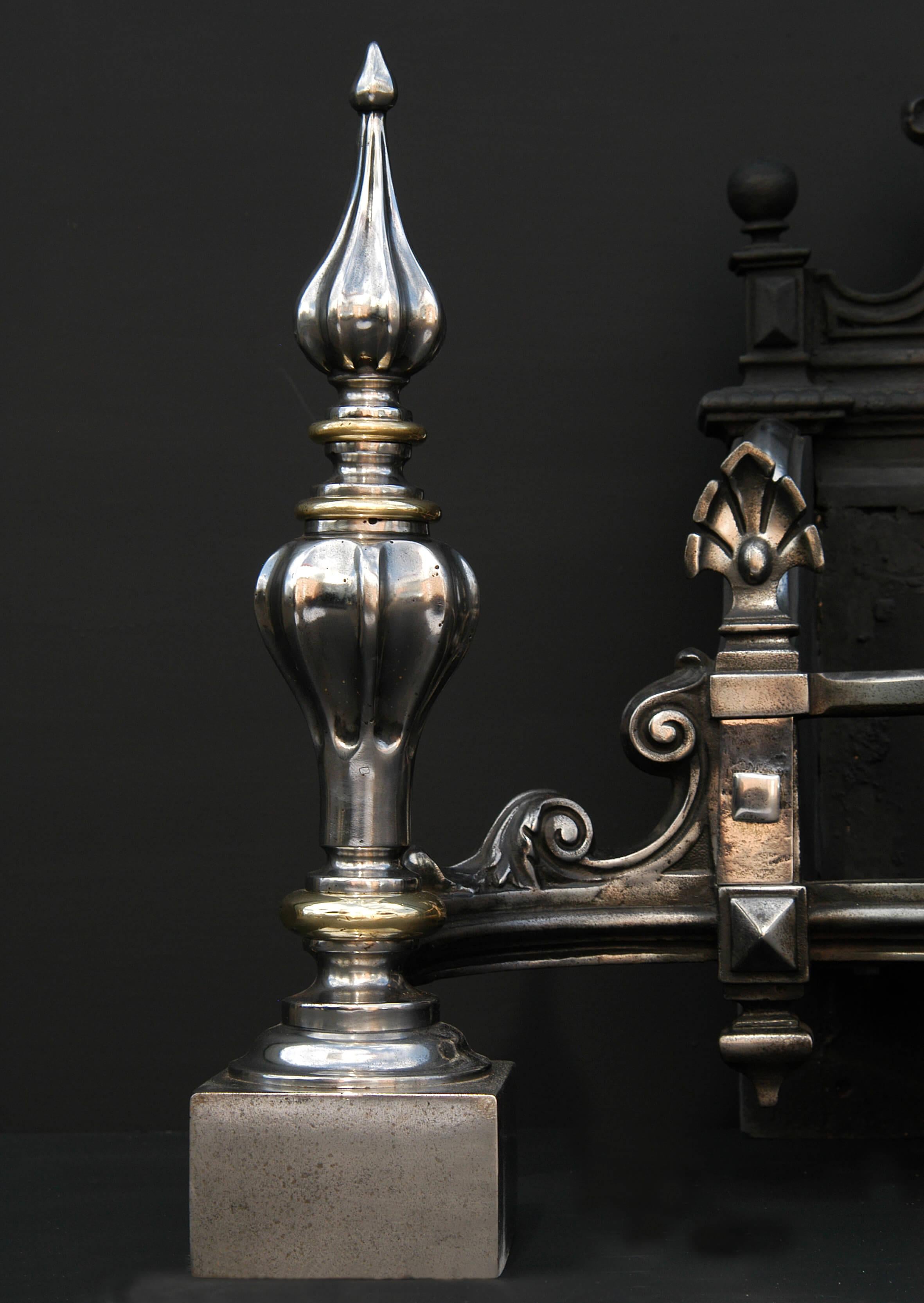 A large 19th century (circa 1840) English Gothic Revival firegrate. The steel firedogs of fluted bulbous form, with brass enbellishments. Decorative cast iron shaped fireback behind.

Width At Front:	1085 mm      	42 ¾