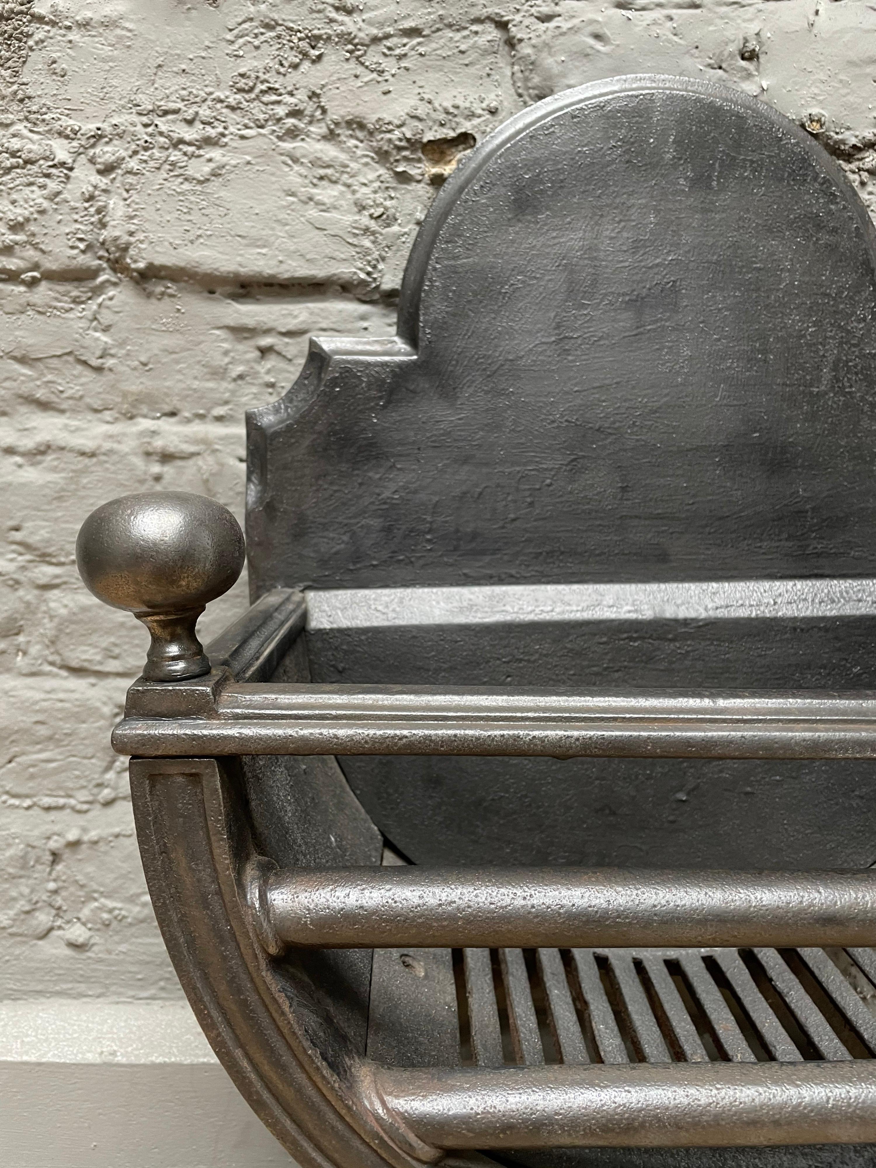 A regency style fire grate in polished cast iron, the X-frame with straights bars, shaped fire back and ball finials. A good quality grate from the 19th century.