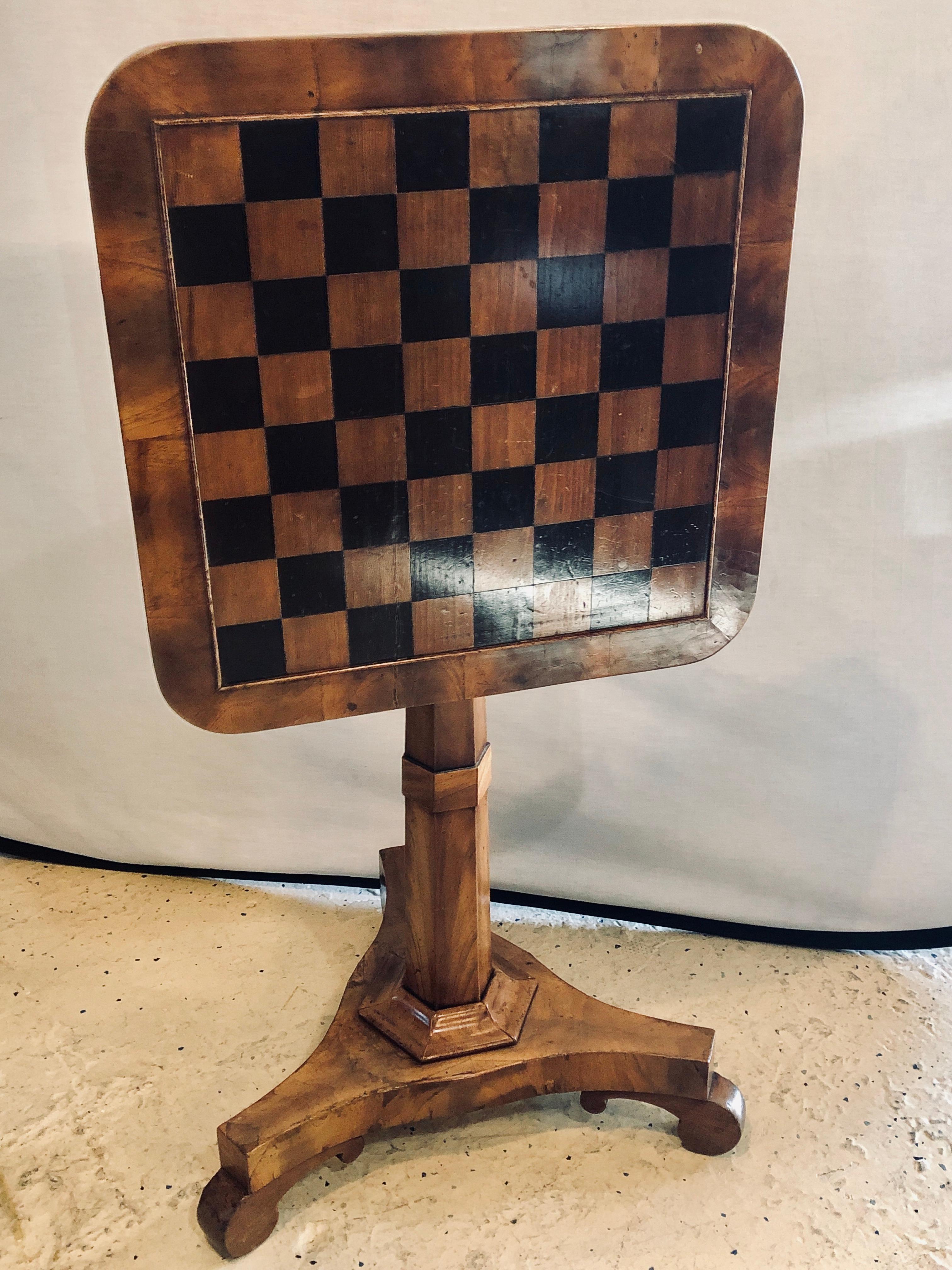 A 19th century English tilt-top game checkerboard or card table. This single pedestal flip top game table sits on a tri pod base and is functional and easy to use.