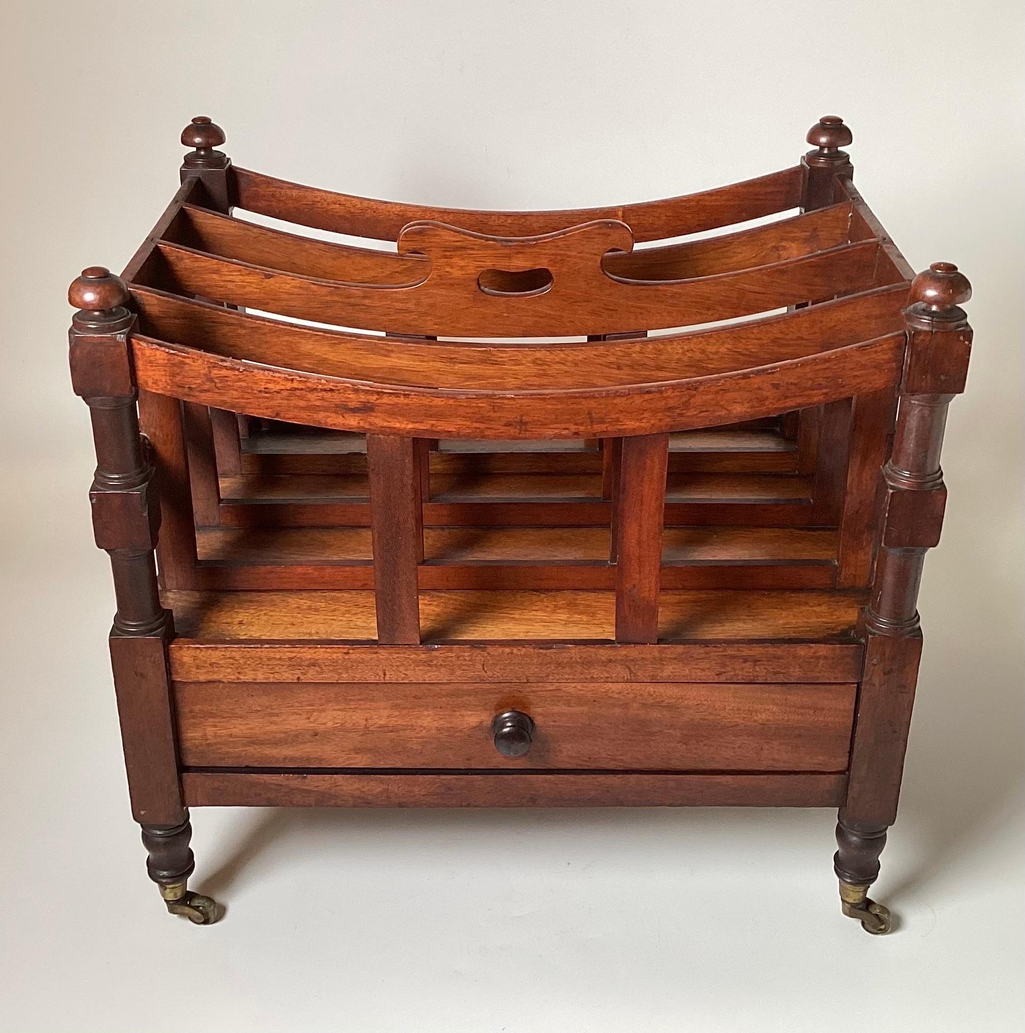 A classic English Regency style walnut music or newspaper Canterbury stand.  The bowed top railings with built in handle with original brass castors, four sections with dovetail construction.  
