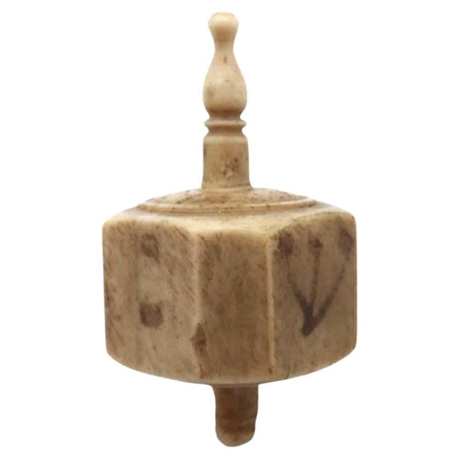 An Excellent 19th Century European Bone Dreidel.

This Dreidel is an early example of the bone dreidels which were made in Europe in the 19th century.

The cylindrical-shaped bone that is pierced through the center of the dreidel is crozier-shaped