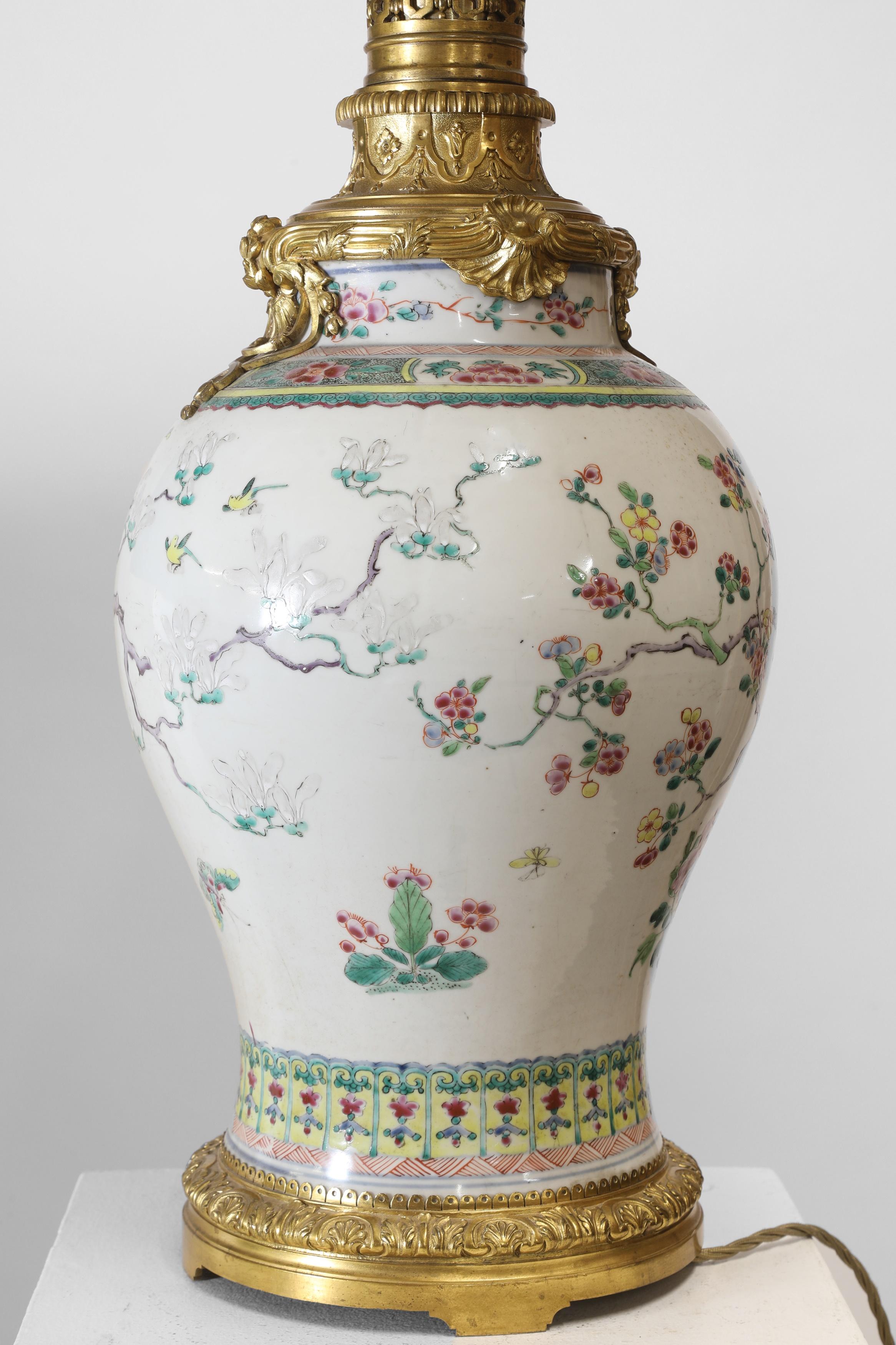 A famille rose porcelain vase,
Guangxu (1875-1908), Chinese, of baluster form, painted with a pheasant standing on a rock and another perched on a blossoming magnolia tree, surrounded by peony and other flowers, now fitted as a lamp.