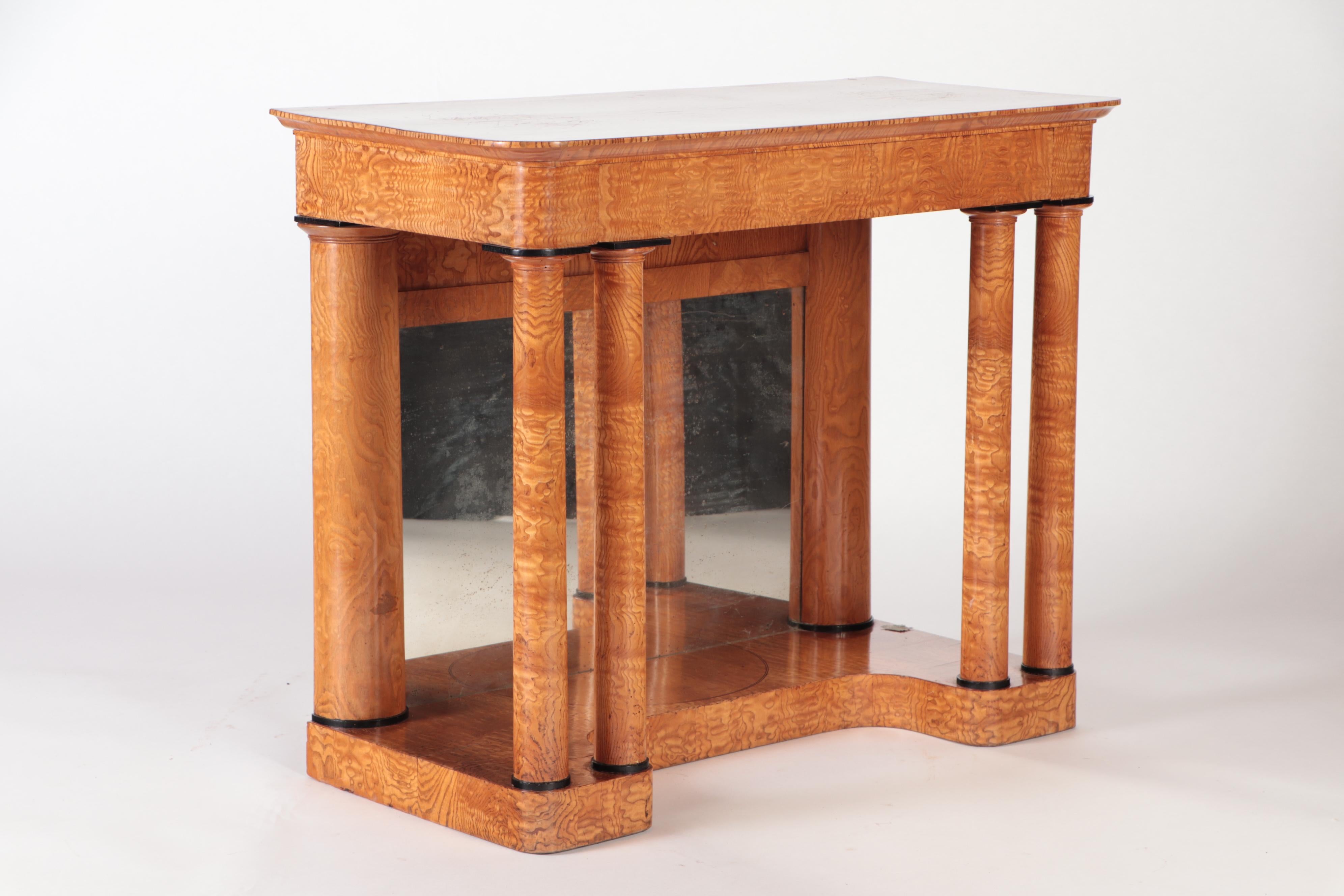 A nineteenth century figured elm console resting on four round Doric style columns. Supporting the legs, the wooden base is concave in its center. There is one central drawer.