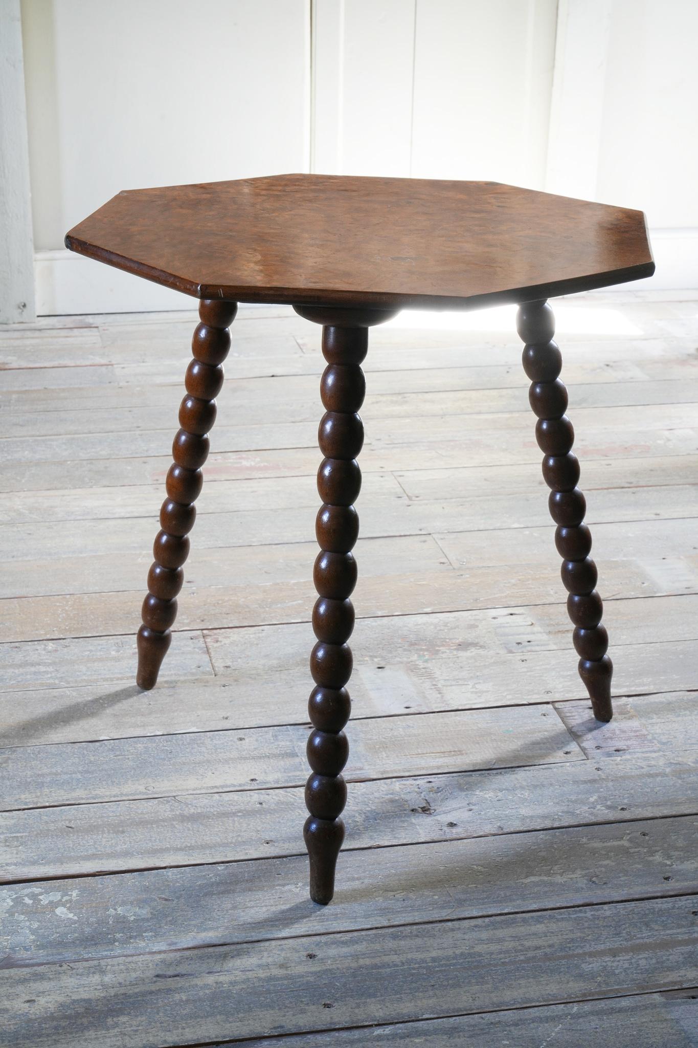 The octagonal top in well figured walnut, supported on bobbin turned mahogany legs.