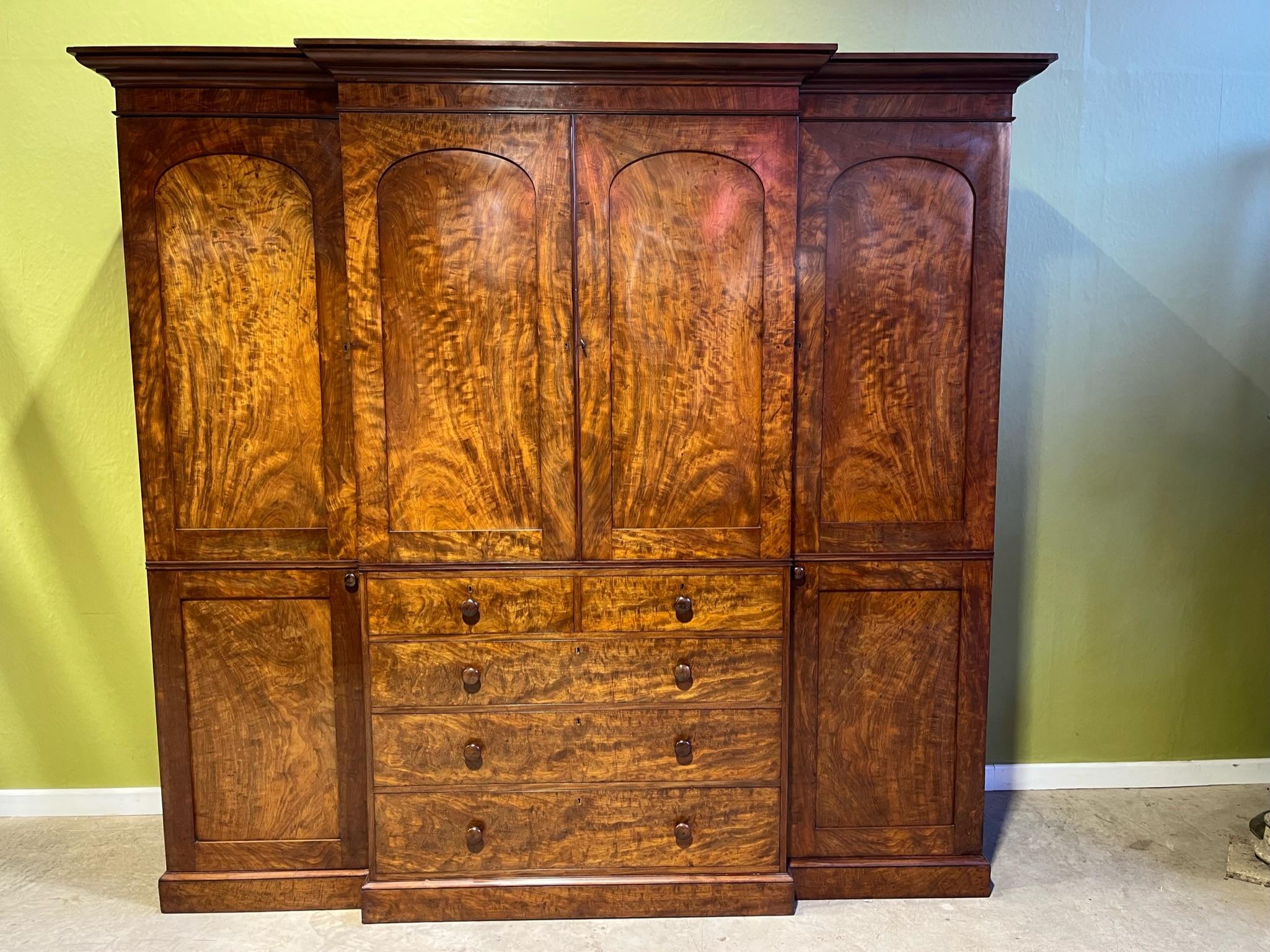 A 19th century flamed mahogany country house breakfront wardrobe, the linen press centre flanked by two sentry boxes with hanging space, in lovely condition with wonderful flamed timbers.

99”1/2 wide x 27”1/4 deep x 93”1/2 high
