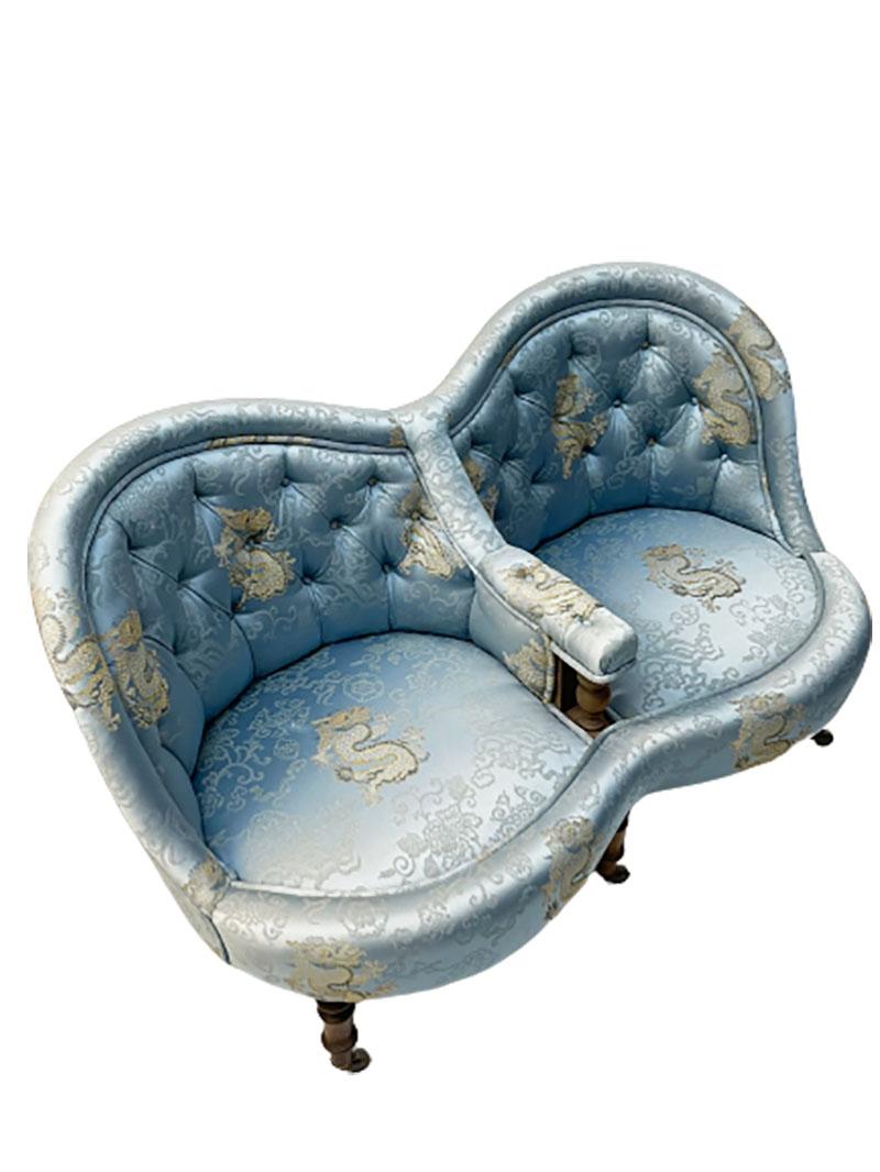 A 19th century French 2-seat sofa

A 19th century French 2-seat sofa or conversation sofa with a padded back and armrest.
The sofa consists of the original chinoiserie satin woven light blue silk with dragons in the clouds on 6 baluster wooden