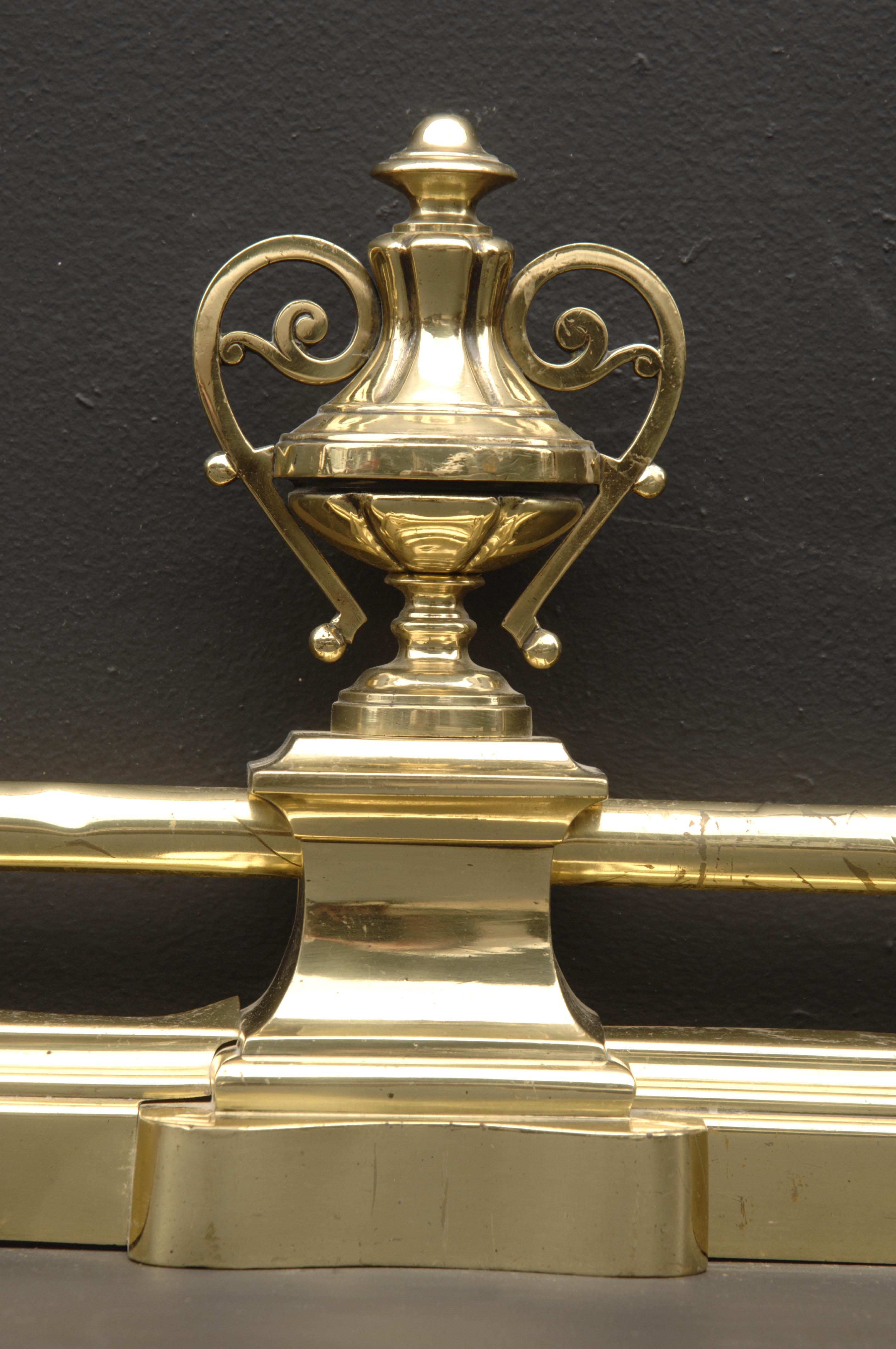 Une défense française du 19ème siècle en laiton avec une barre supérieure droite et des urnes avec des poignées aux extrémités. 

Largeur externe :	1029 mm      	40 ½