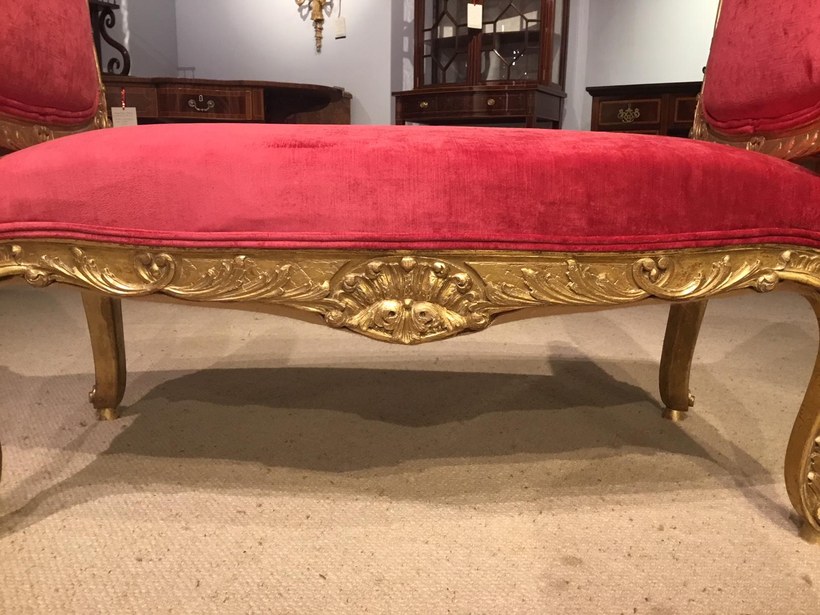 A 19th century French carved giltwood stool. Each end having finely carved giltwood detail with padded supports and a sprung serpentine seat. With finely carved detail to the show frame and supported on acanthus carved gilded supports, newly