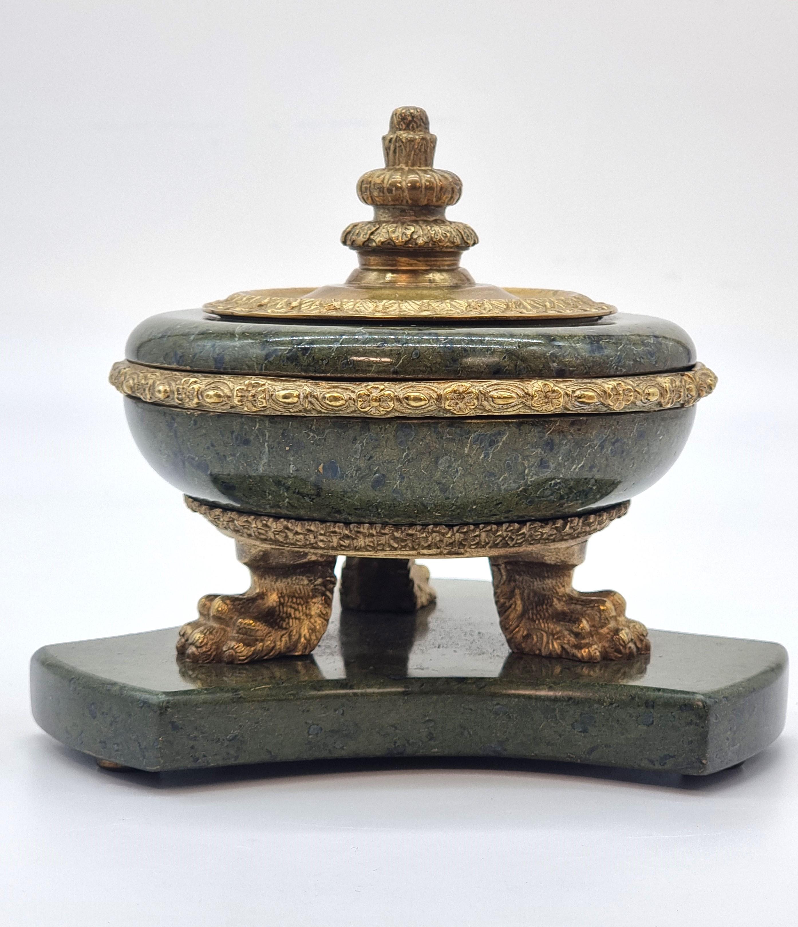 This very stylish French Empire gilt bronze and marble inkstand is a fine example.

It is made from superb figured green marble.  The triform base is raised onto bronze pads. The main inkwell body is in matching green figured marble which is raised