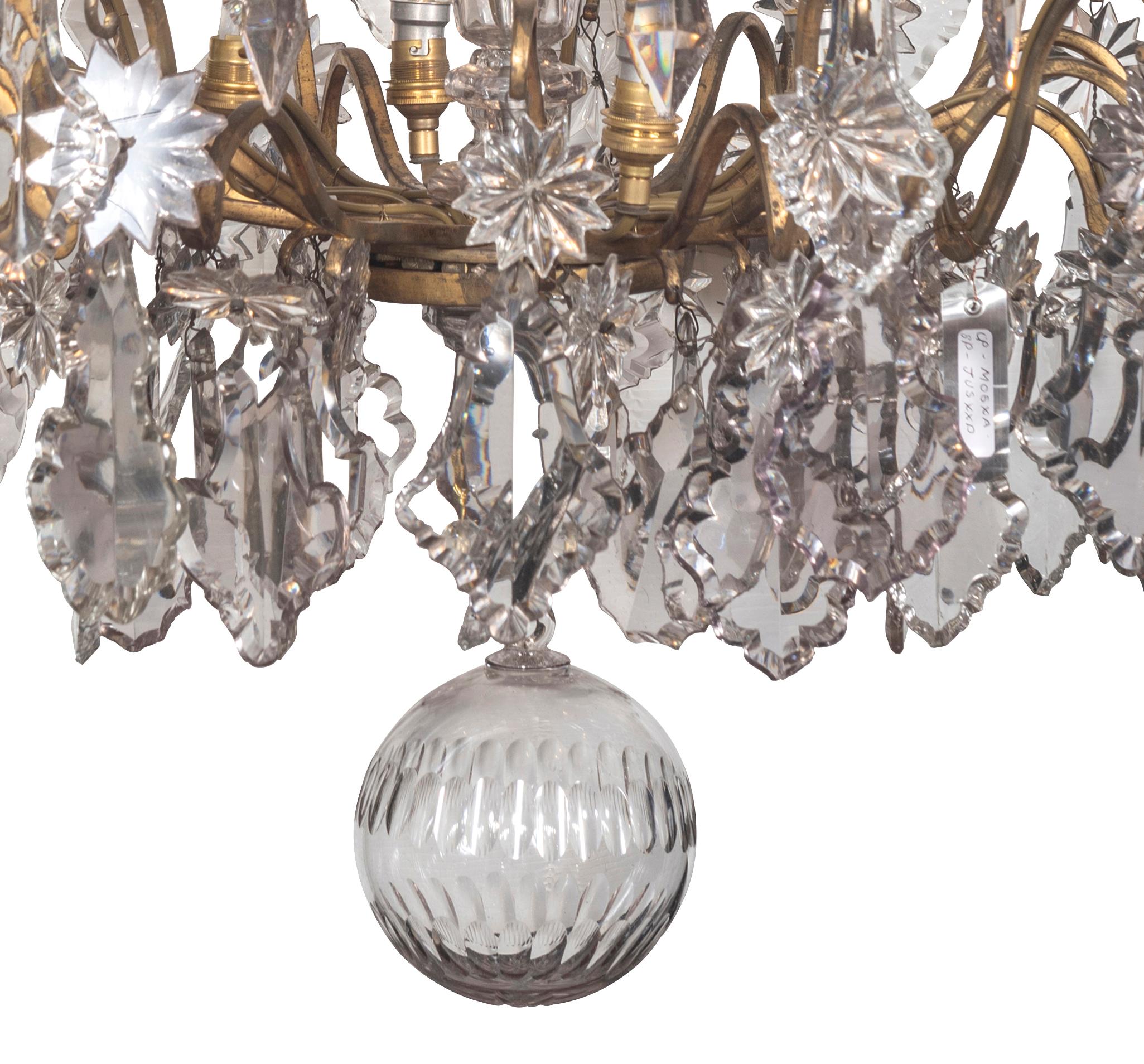 The corona issuing rising tendrils with pear drops and rosettes, the central crystal graduated baluster stem with conjoined scroll arms, the upper tier with further pear and rosette shaped drops continuing to the lower tier with 32 rising scroll
