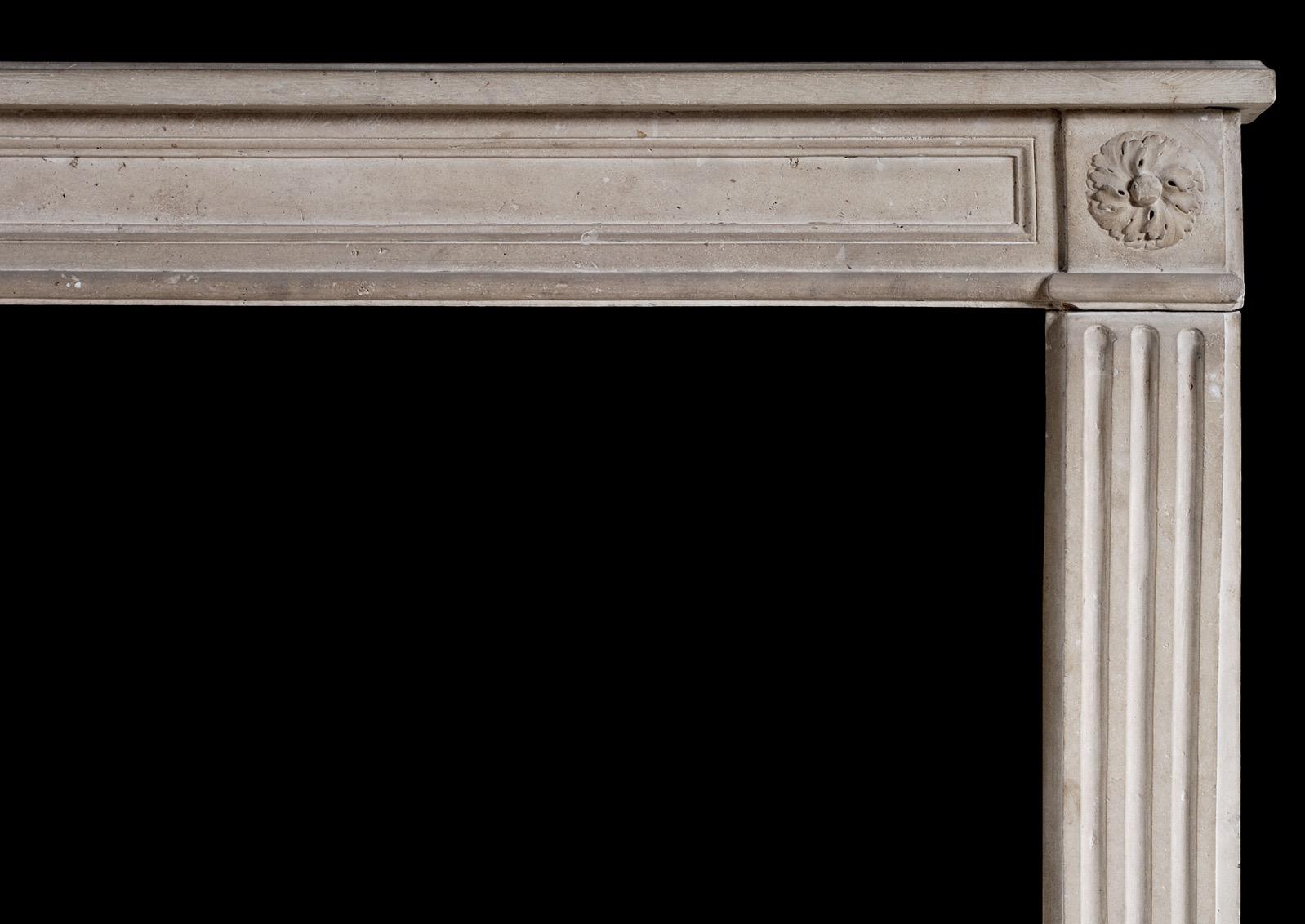 A 19th century French Louis XVI style stone fireplace. The fluted, shaped jambs surmounted by swirling carved paterae, the panelled frieze with moulded shelf above.

Measures: Shelf width 1605 mm 63 ¼