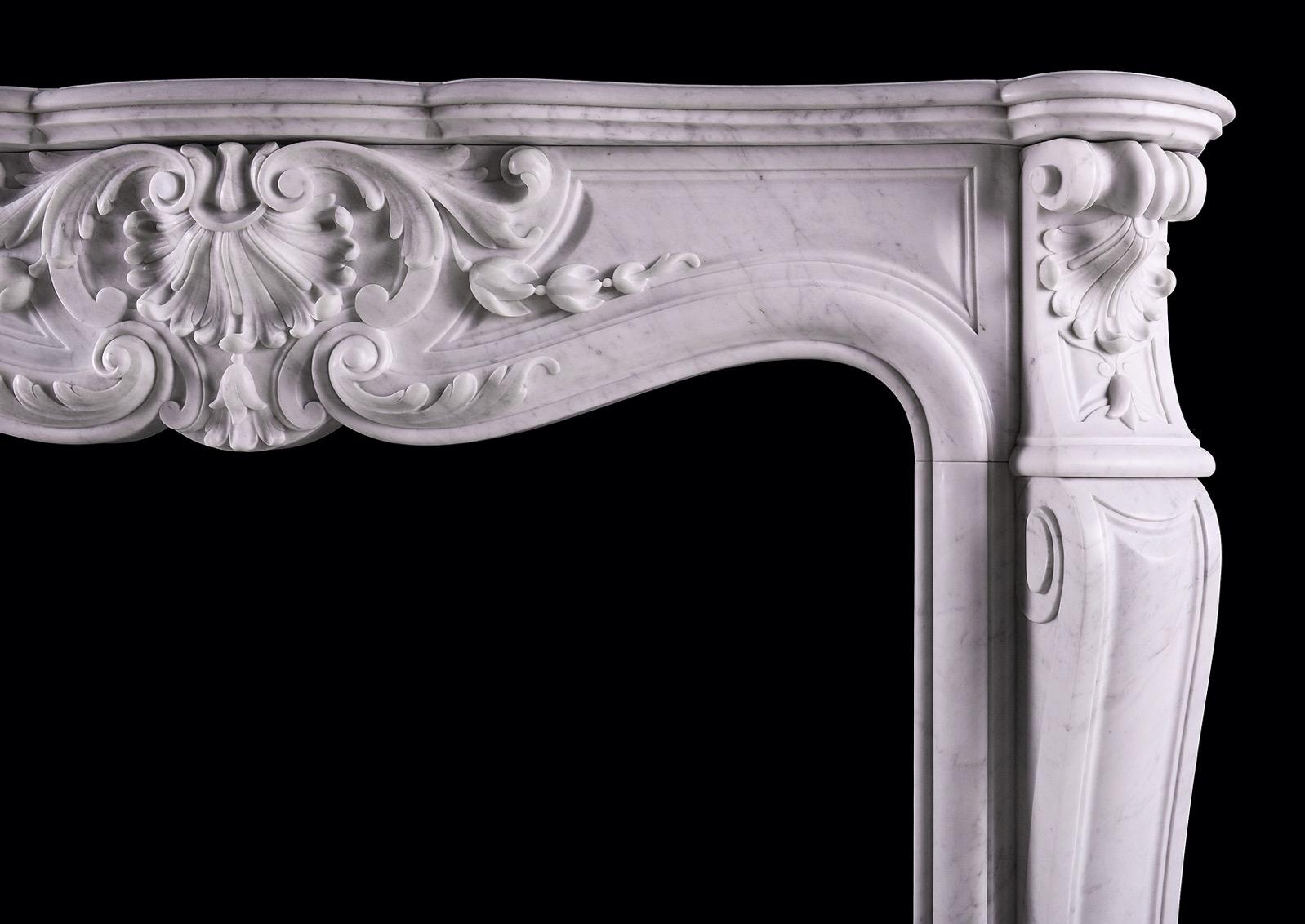 A 19th century French marble fireplace in the Louis XV manner. The panelled frieze with shell to carved centre, with scroll work throughout, the carved jambs with stiff acanthus leaves to base, surmounted by shaped legs and carved end blockings