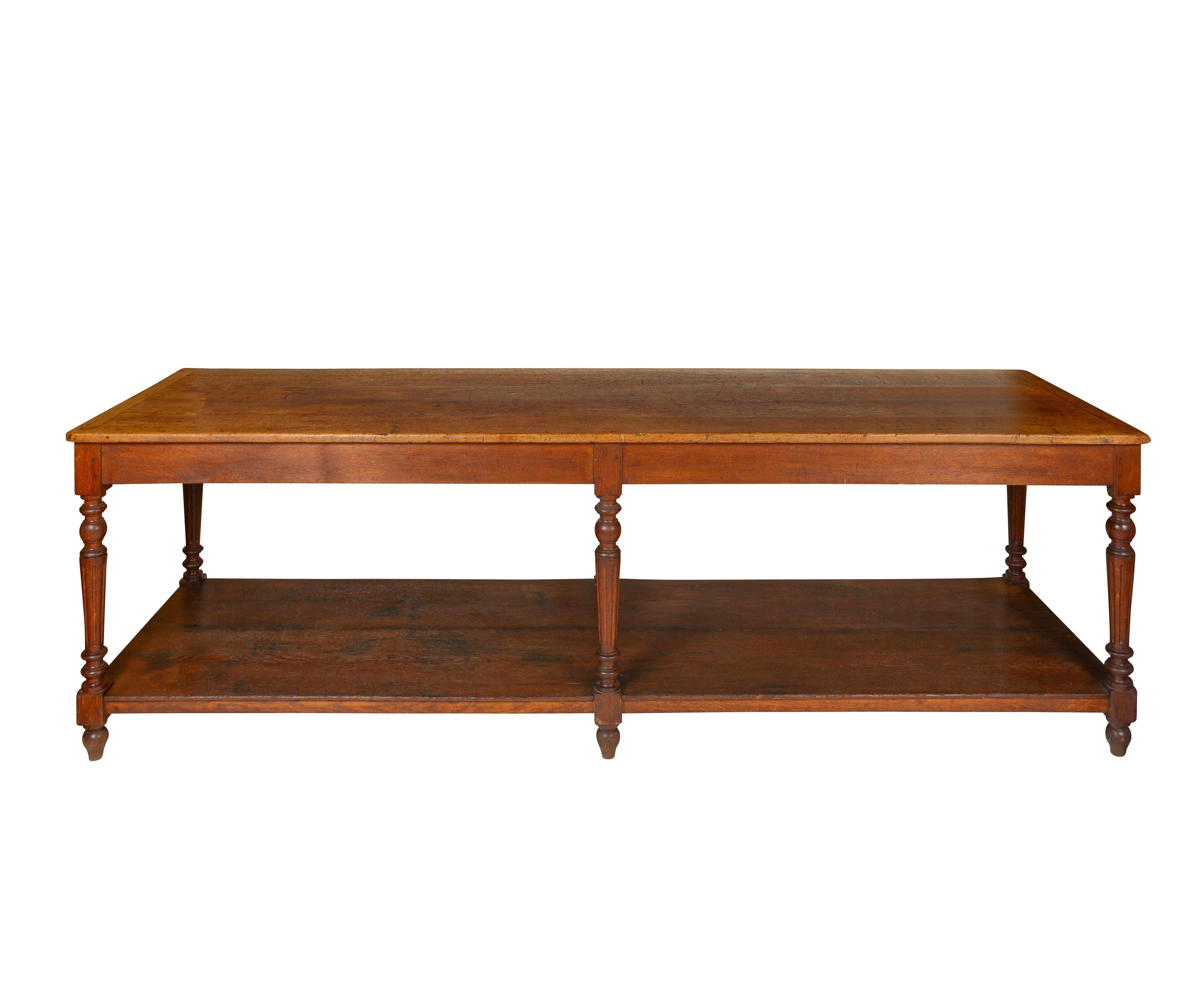 The top of rectangular form with overhanging edge, supported by six baluster-form, turned legs with lower shelf.