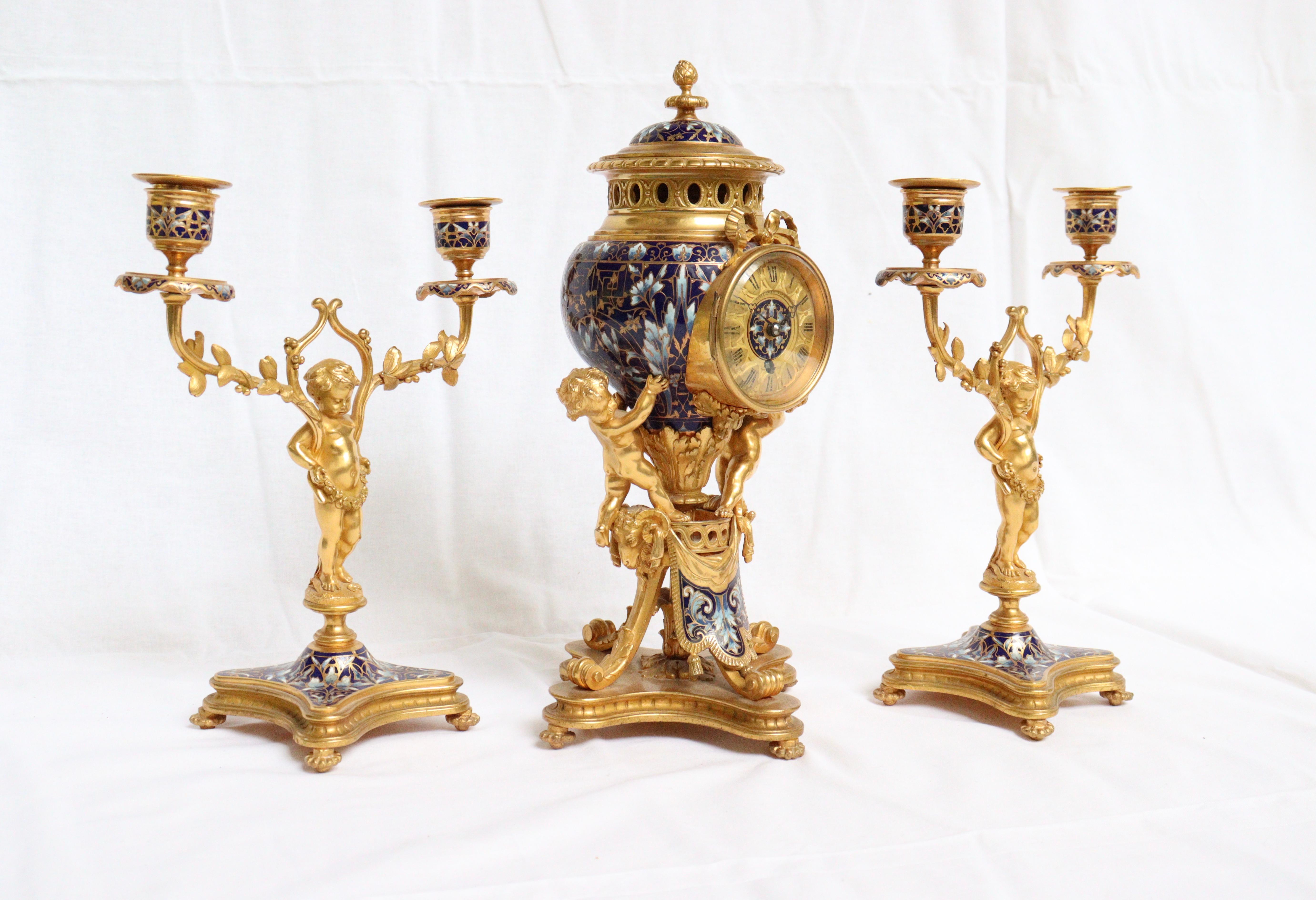 A 19th century French ormolu and cloisonne´ enamel three-piece clock garniture set
This three-piece antique French clock set features delightful gilt bronze models of cherubs, together with some incredibly intricate floral cloisonne´ enamel work,