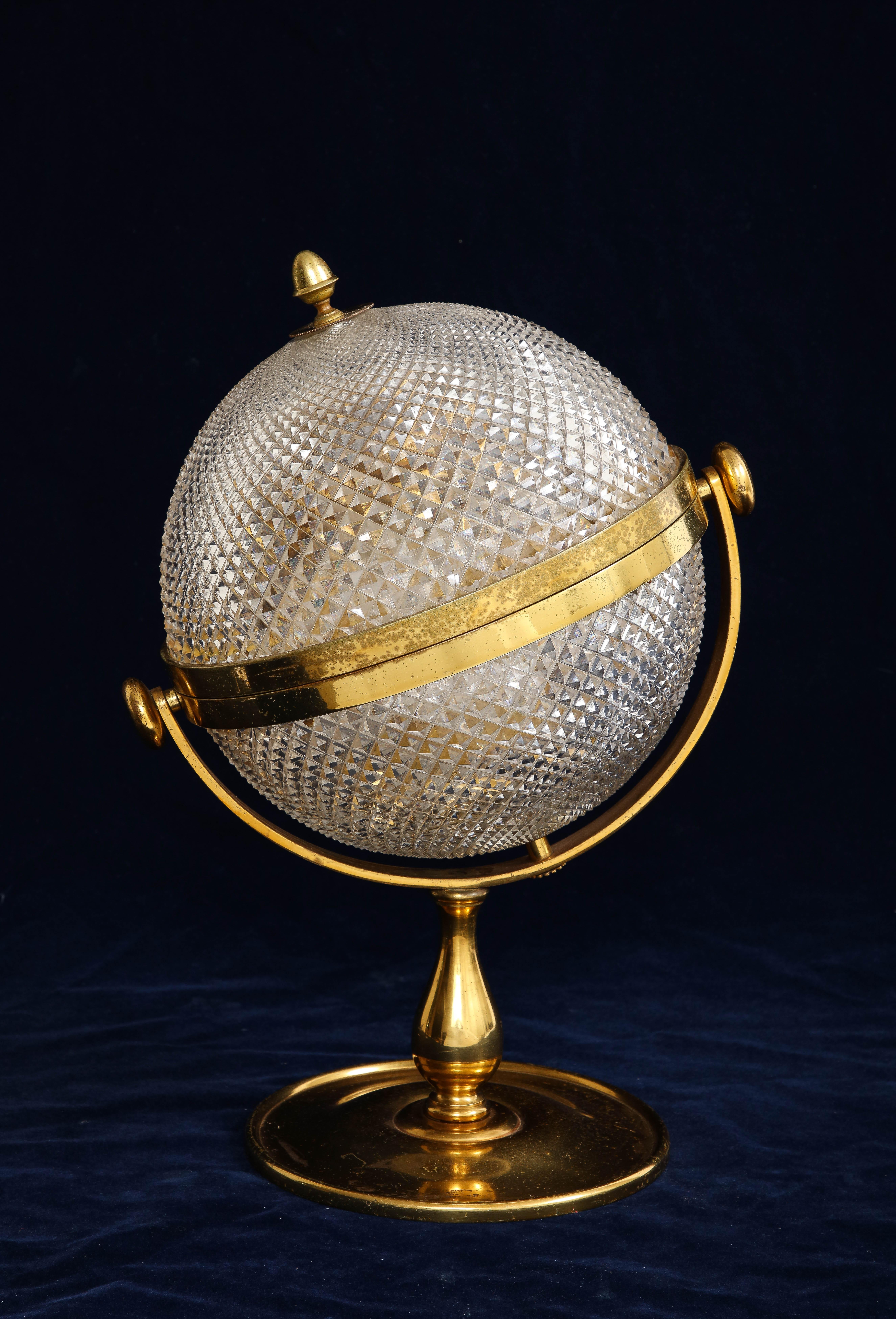 An Unusual 19th century French Ormolu Mounted Globe Style Tantalus liquor set. The round globe top which rests on an elongated ormolu base is not common to find. The crystal top is mounted in an ormolu case and consists of three hand-cut crystal