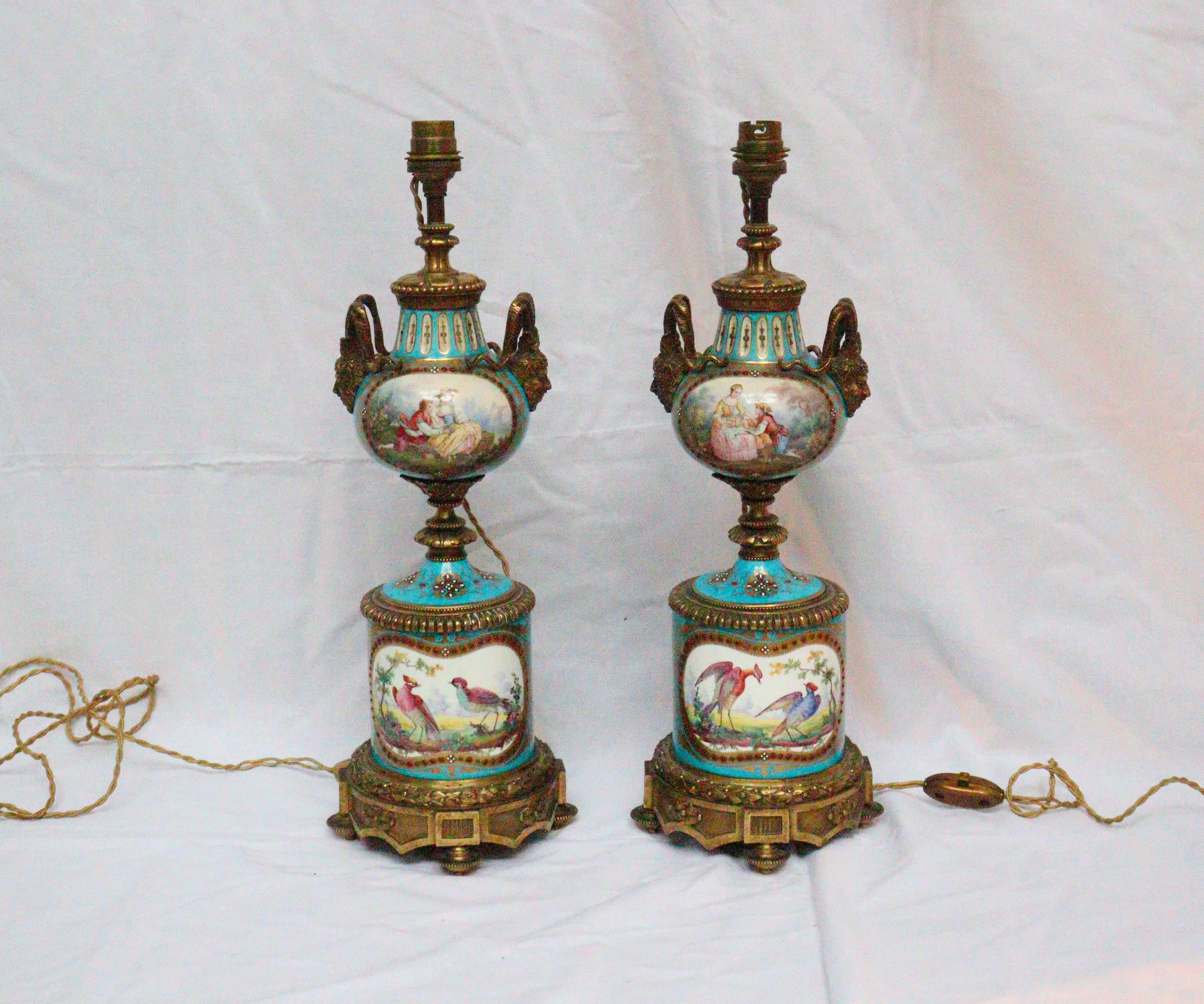 A 19th century French pair of celeste blue ground Sèvres Porcelain vases,
having pearl beads and hand-painted gilt decorated and ‘jeweled’ bodies, waisted ormolu centers, with shaped cartouches depicting on one side bucolic pastoral scenes and