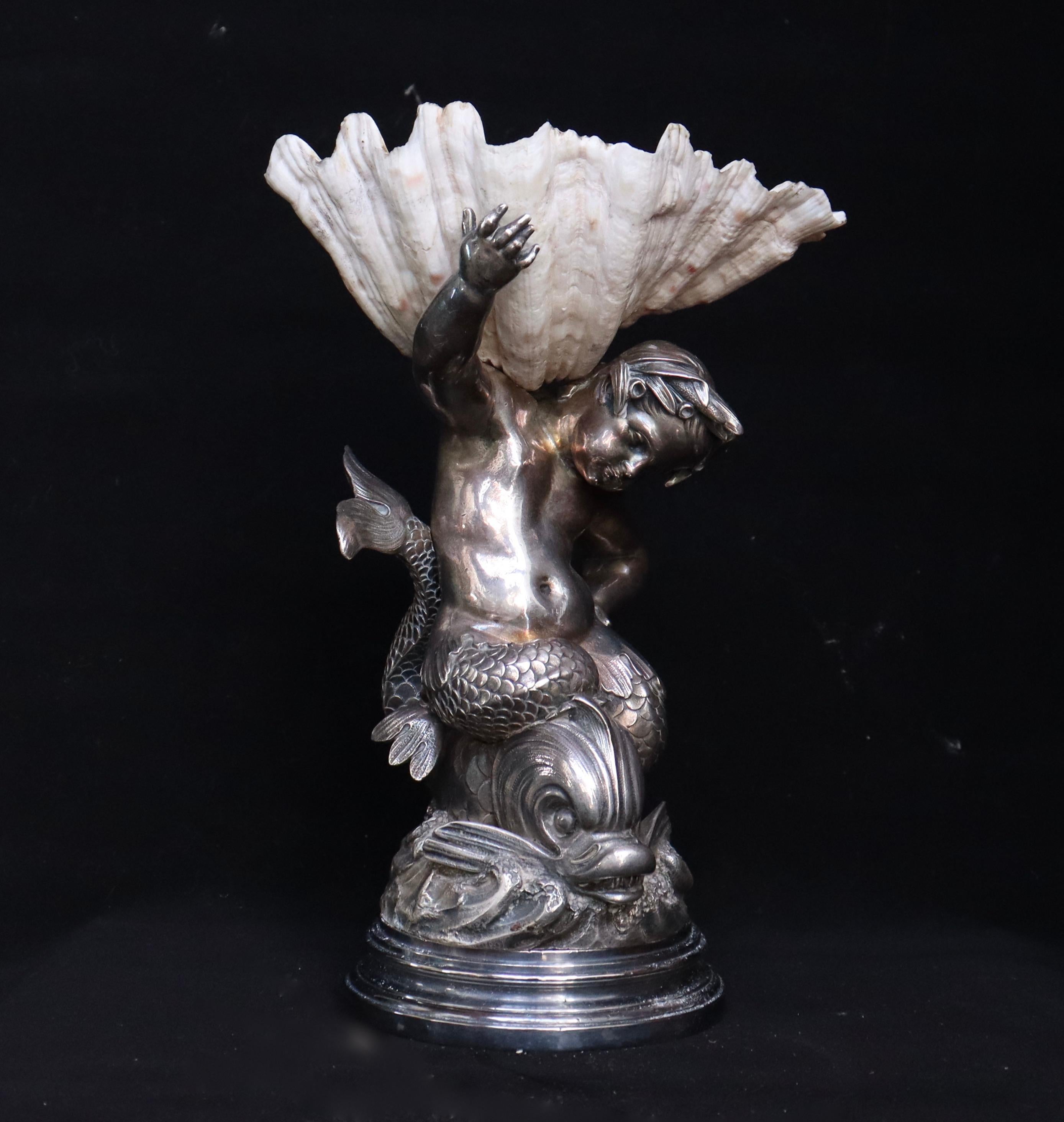 A French silvered bronze-mounted shell centerpiece
The stem cast and chased as a dolphin-riding triton above a circular base
The figure supporting a natural shell Tazza,
XIXth century,
Circa 1870.