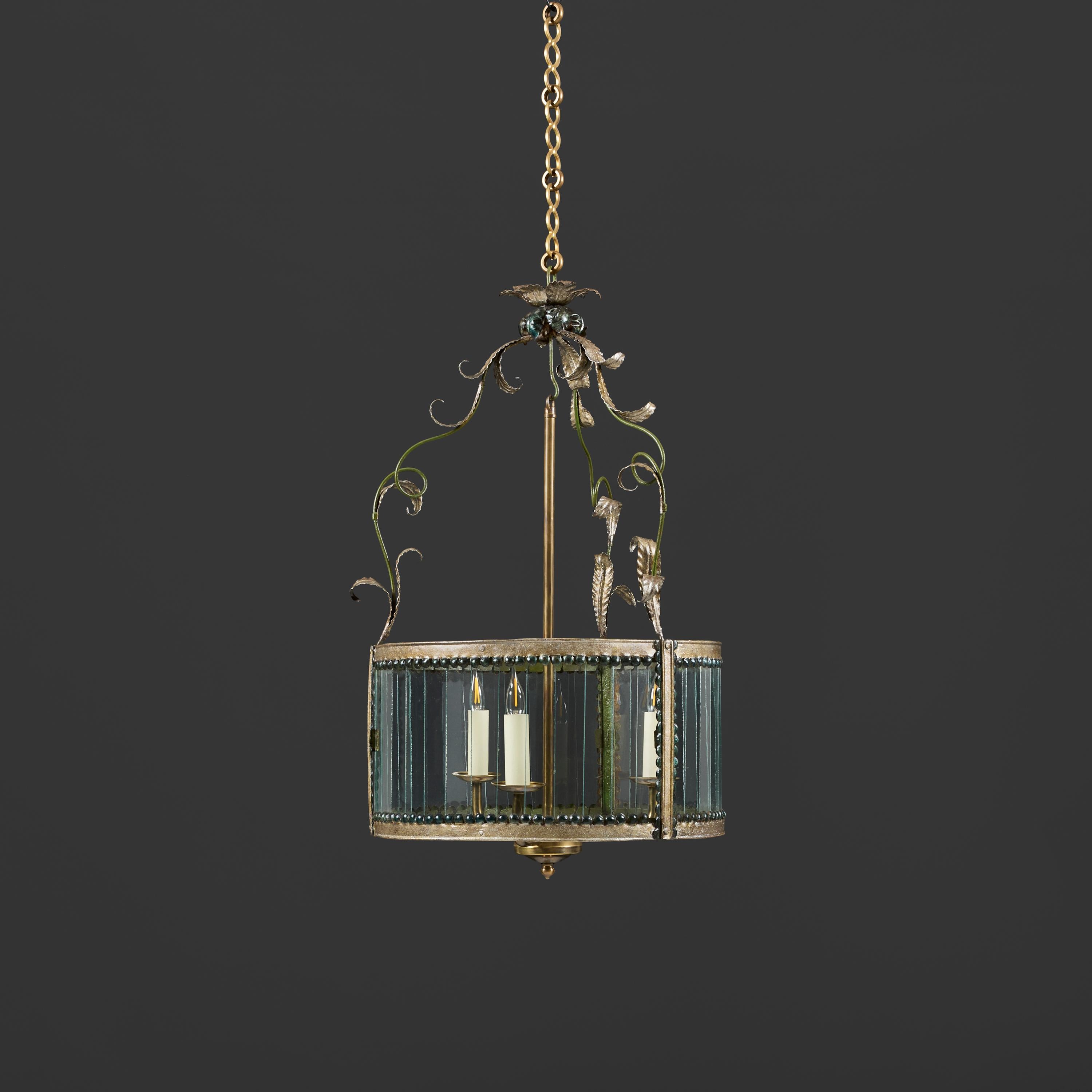 France, circa 1890

A late nineteenth century French tole hanging lantern of drum form, with glass segments to the body, supported by three scrolling vines with leaves joining in a floral crown, with chandelier element with three candle arms.

Total