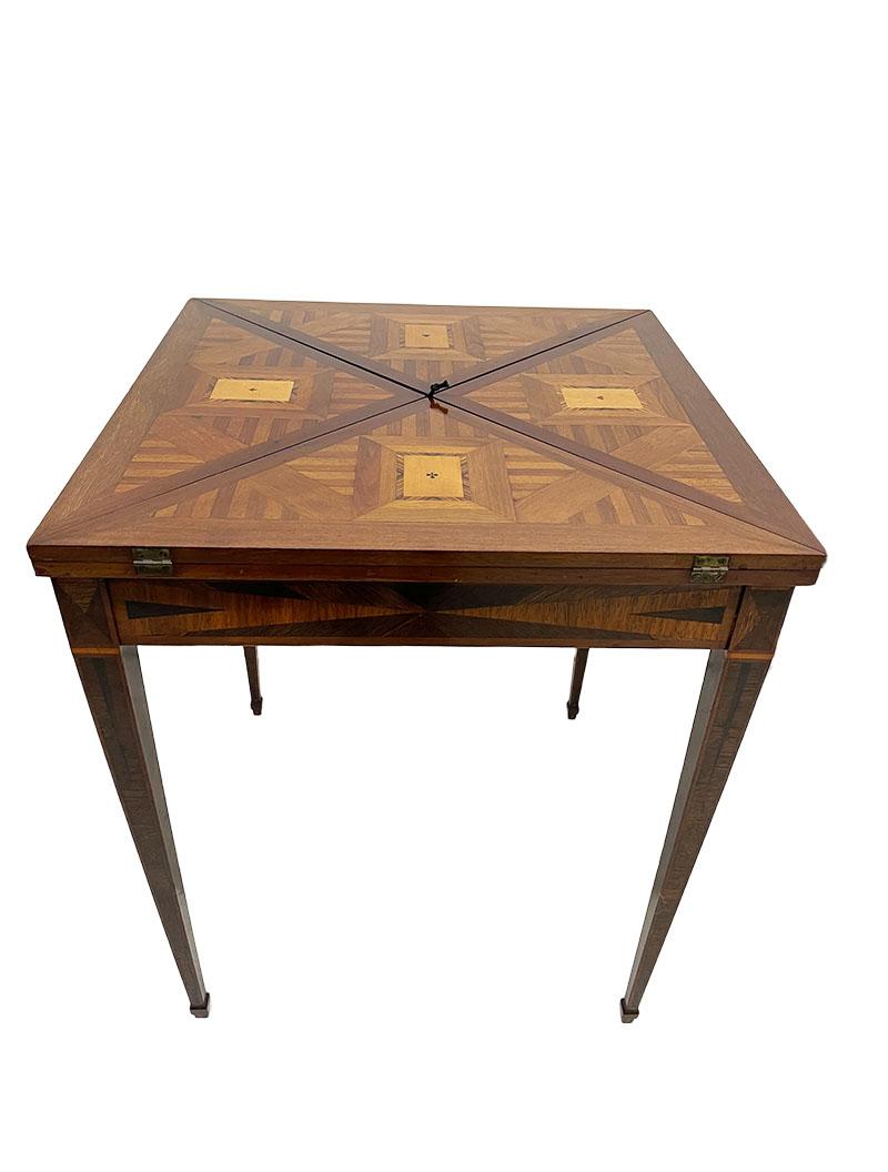 A 19th Century French with intarsia folding handkerchief card table

A mahogany with fruit wood intarsia inserted card table. 4 triangle table tops with intarsia embedded card game scene, which are unfolded after the top is first turned. The inside