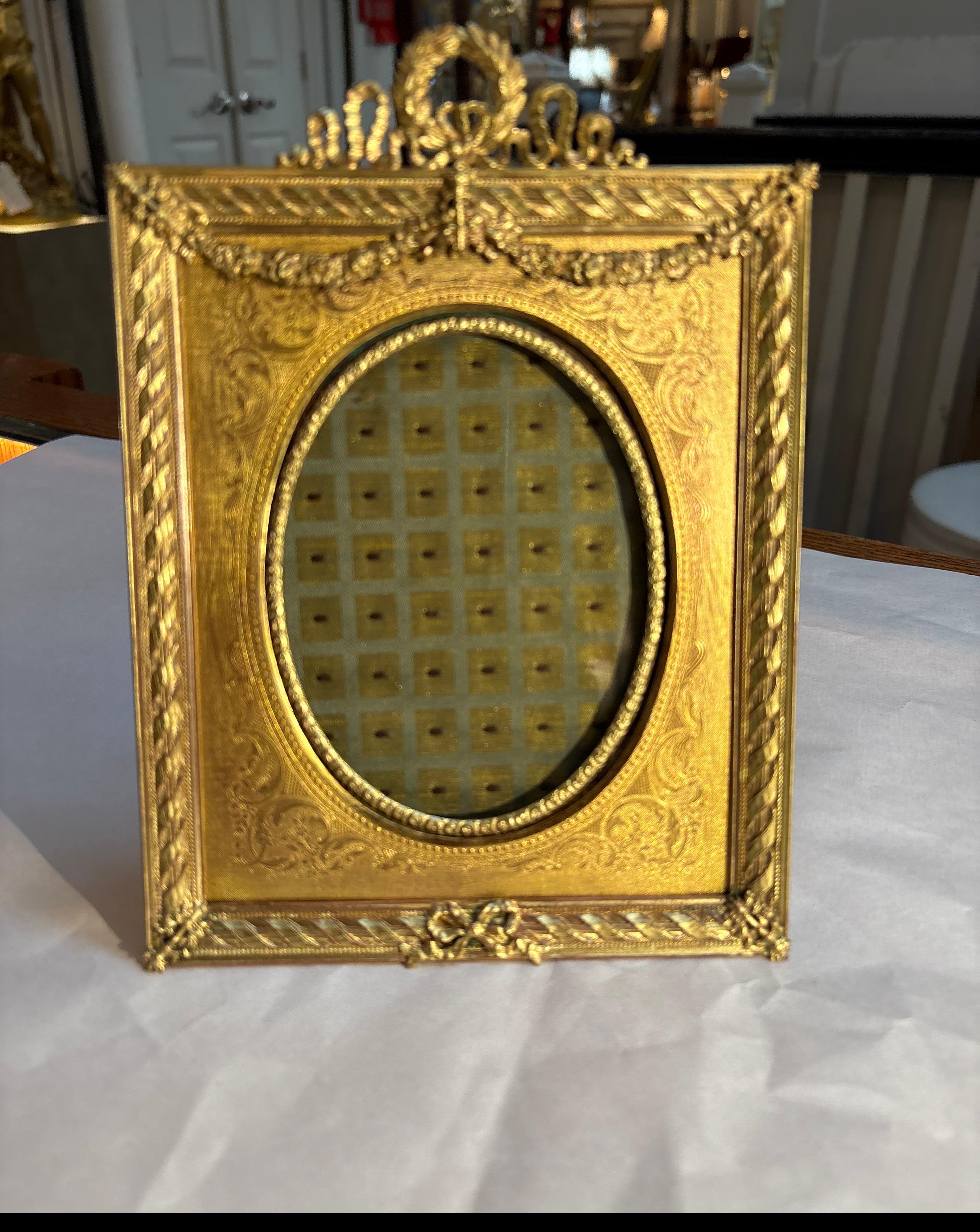 Un élégant cadre photo sur pied en bronze doré avec un mat ovale en bronze doré avec une ouverture frontale de 4,5 de haut, 4,5 de large.  Le chevalet attaché.  Le dos est estampillé  Fabriqué à Brooklyn NYC
