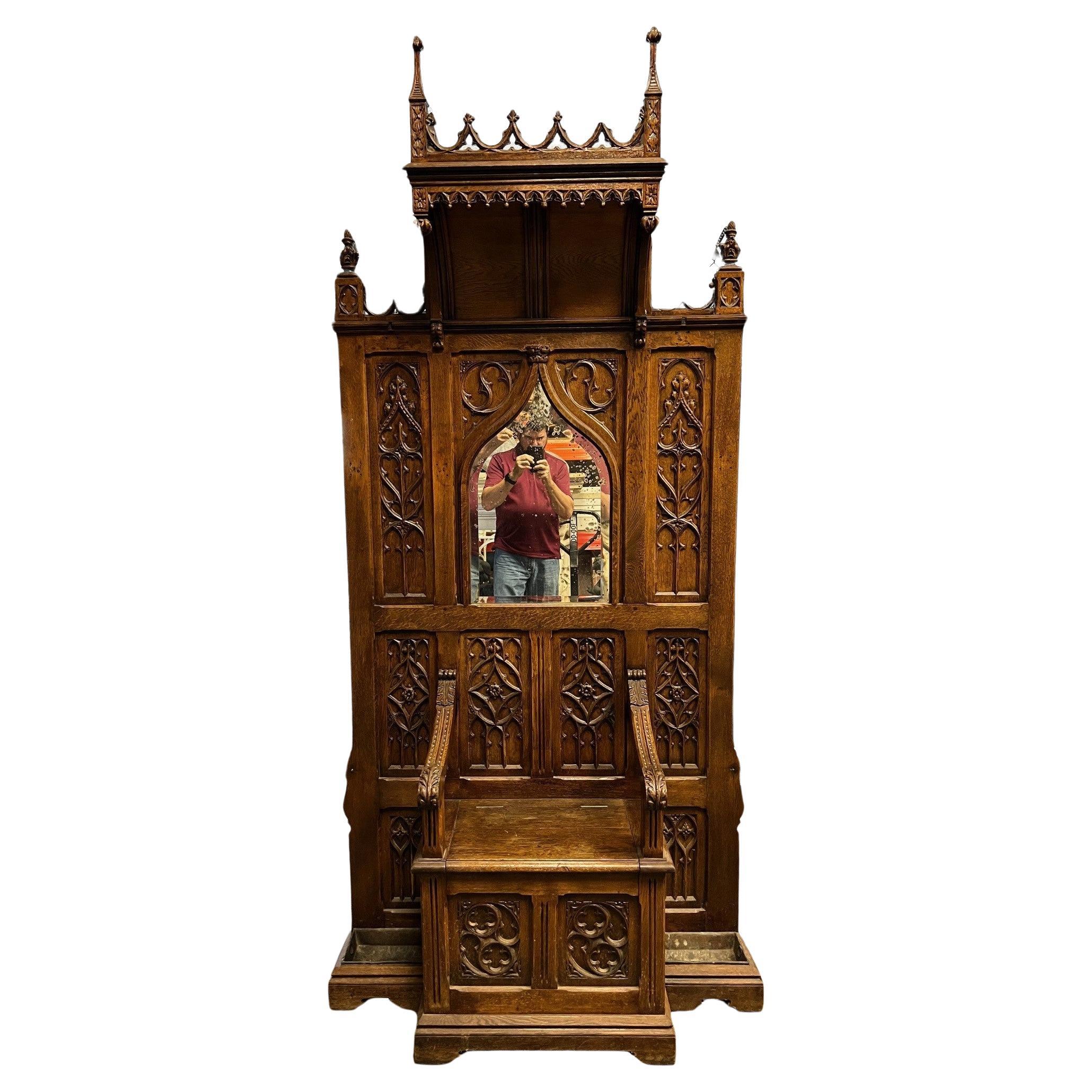 A 19th Century Gothic Carved Wood Hall Tree with Seat and Mirror.