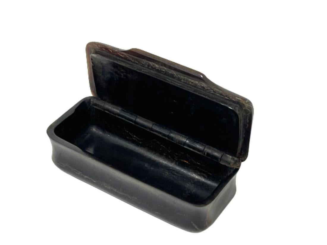 A 19th century snuff box with intarsia

A horn snuff box with a diamond-shaped embedded smaller diamond-shaped surfaces on the box in relief. The box has been a utensil and is in good condition

The measurement of the box is 2.5 cm high, 8.8 cm wide