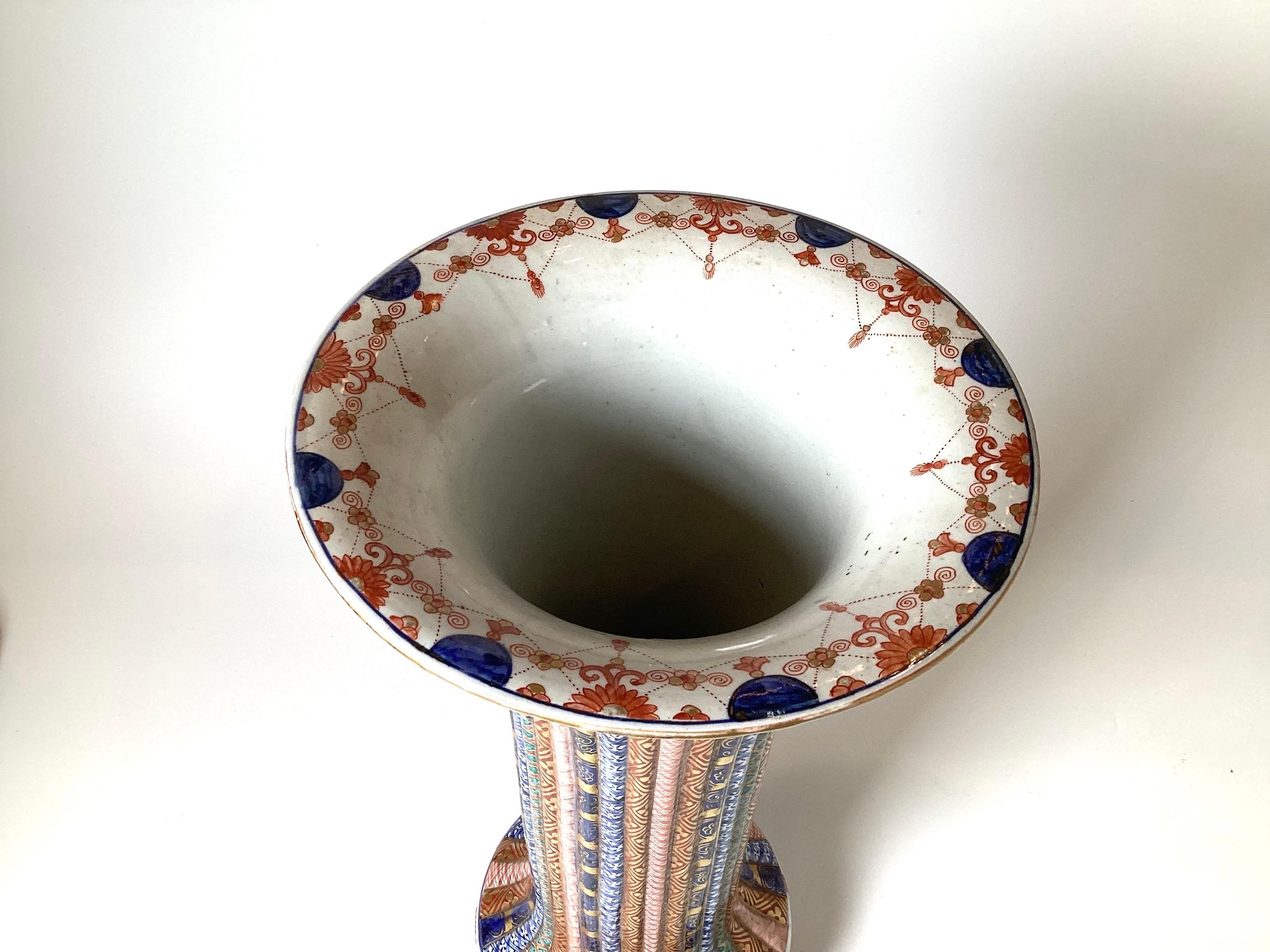 A remarkable hand painted Japanese Imari porcelain trumpet vase with ribbed body and profuse decoration. This vase is very rare and unique in its decoration and quality of the artist painting. Measure: 21.5 inches tall.