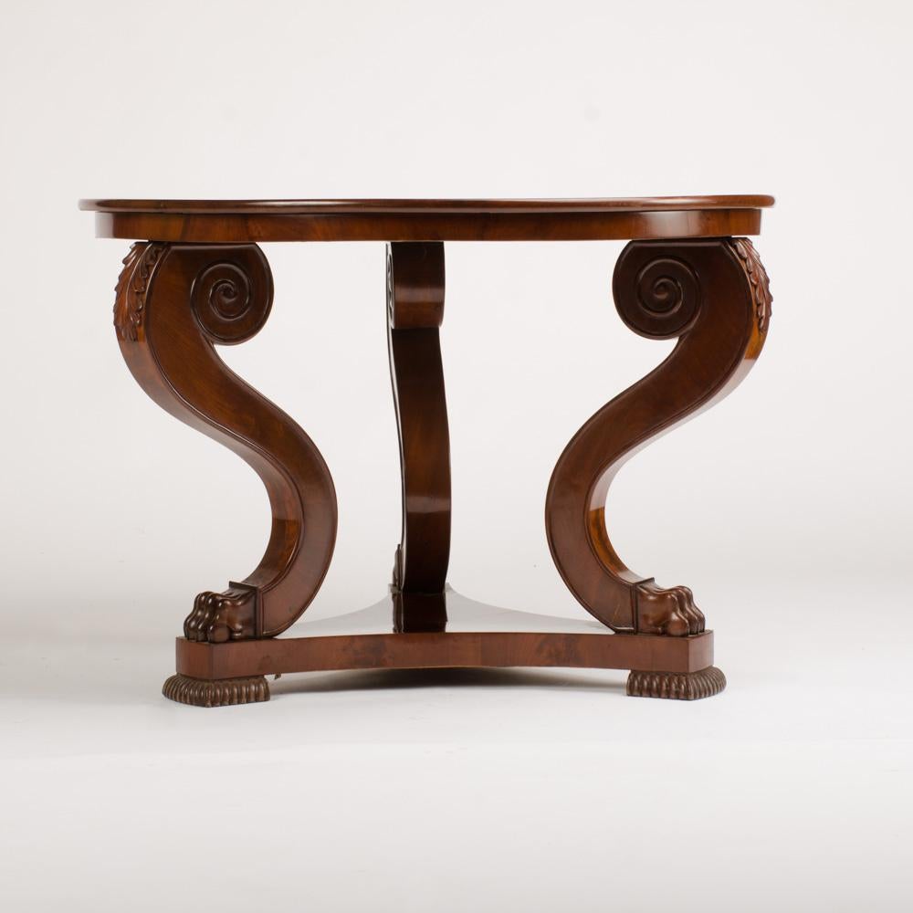 An imposing 19thC Irish Empire entrance center table in rich mahogany. Three scrolled legs terminating in paw feet.