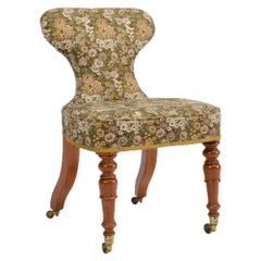 A nineteenth century Irish mahogany upholstered chair with brass casters.