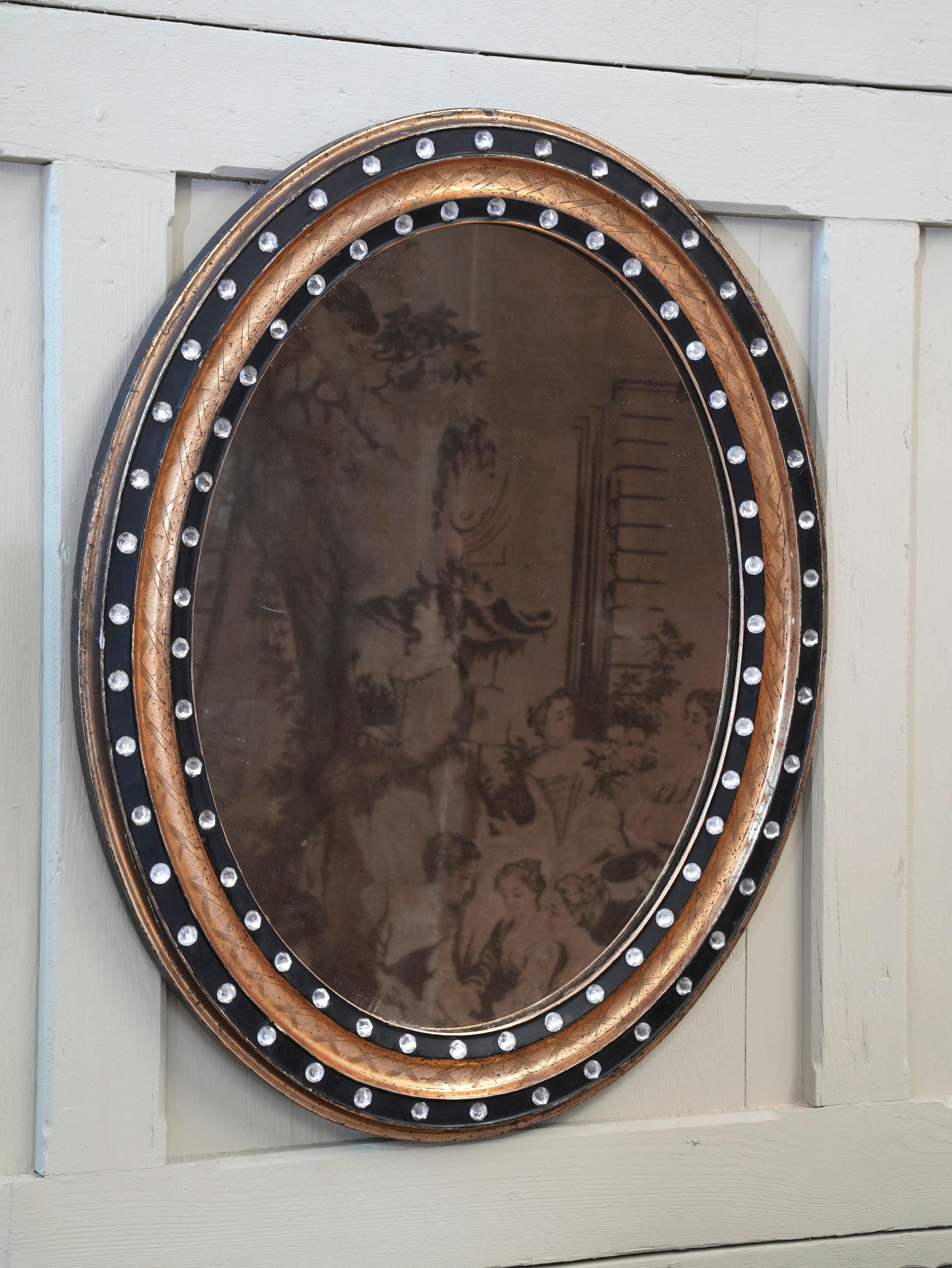 An early 19th century Irish wall mirror.

The raised ebonised slips retaining the original faceted glass decoration, separated by a gilded and X decorated recess.

Original mirror plate and pine backboards.