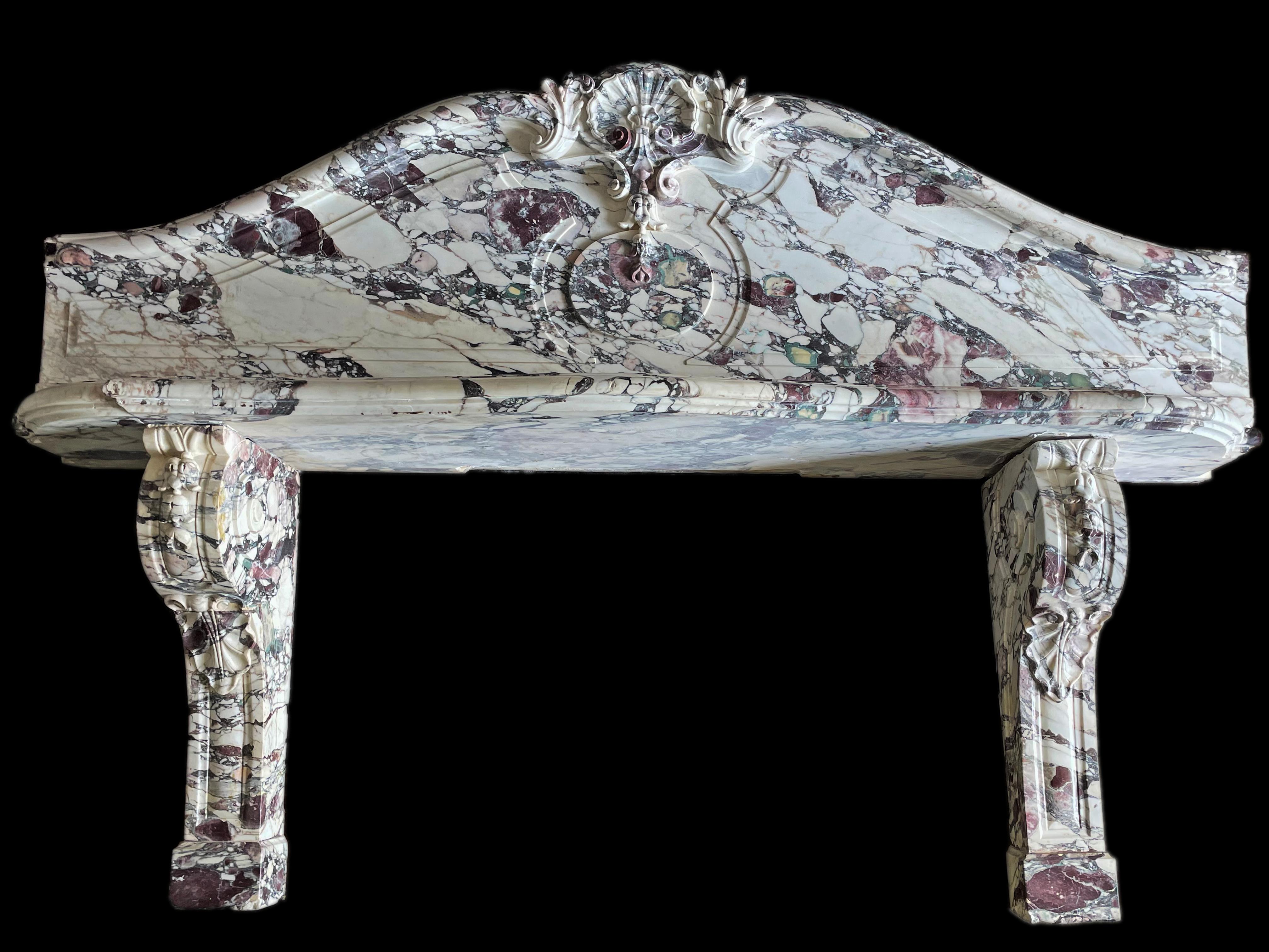 An Impressive and Monumental 19th Century European Elaborately Carved Italian Carrera Viola marble mantel surround with white and purple veining throughout with intricately hand carved scroll legs with carved shelf and carved frieze in classic 19th