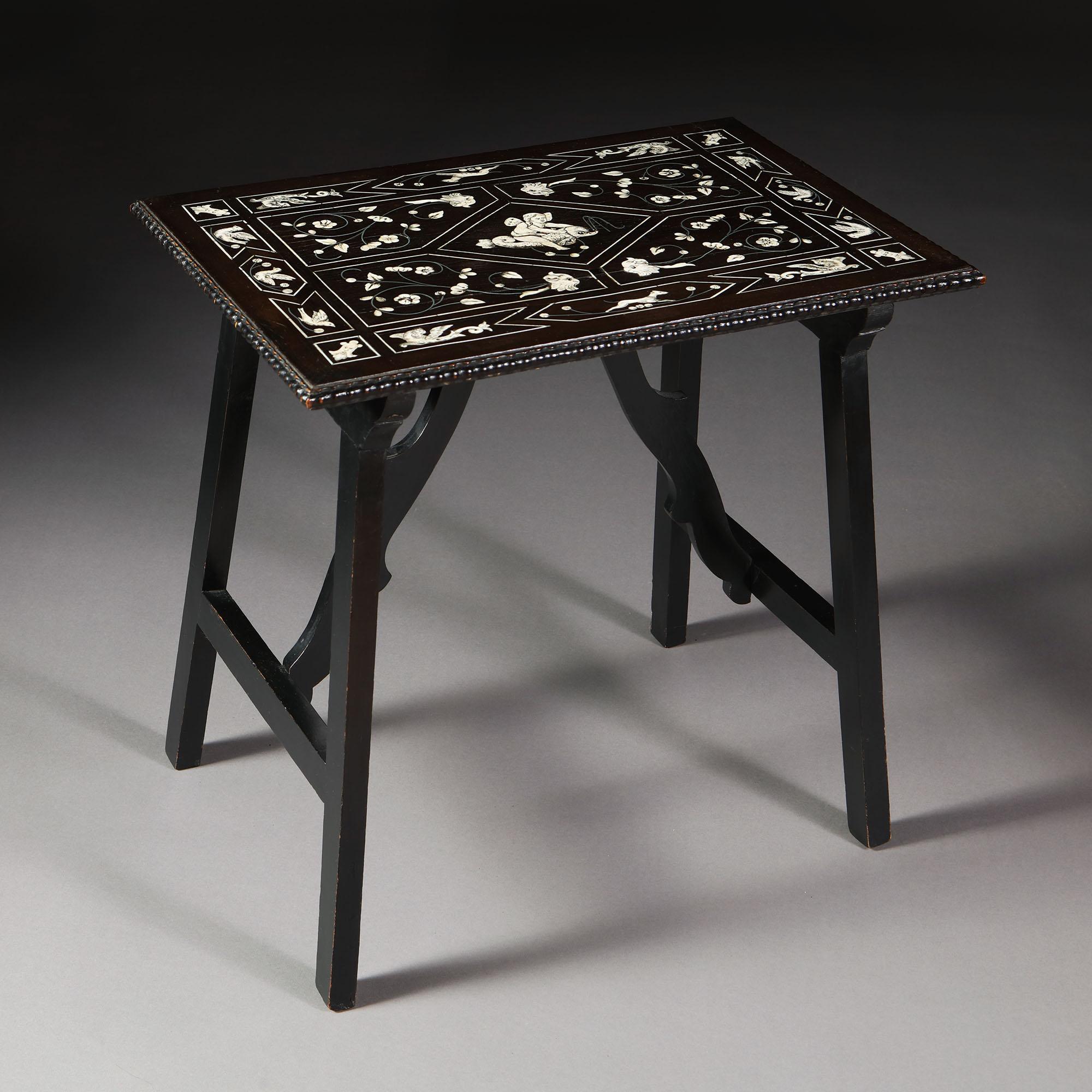 A mid nineteenth century Italian ebony side table, the top decorated with bone inlay, depicting masks, floral motives, and a central image of a cherub riding a dolphin, with unusual scrolling stretchers to the base.