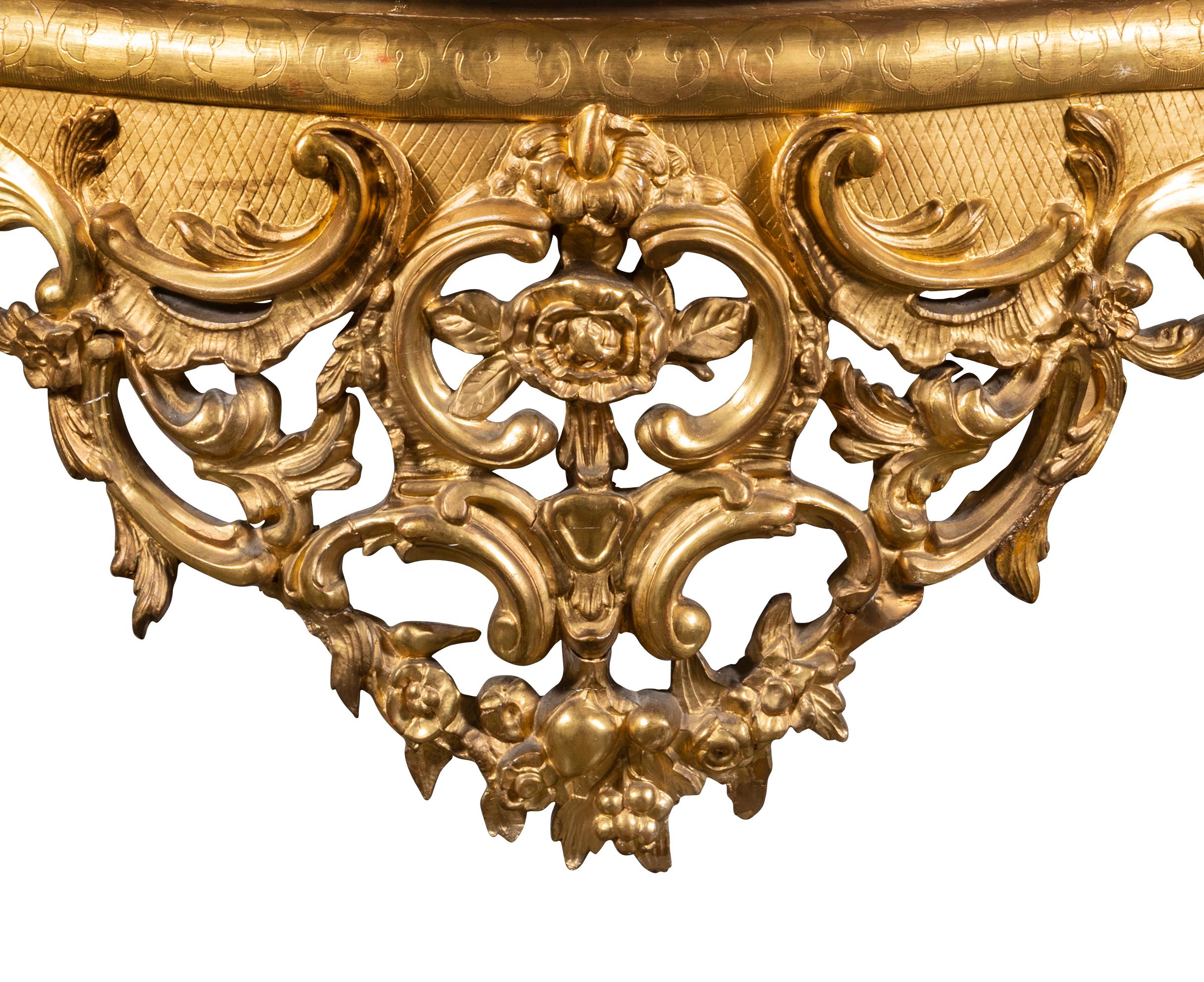 The serpentine fronted Carrara marble top over heavily gilt and carved frame, the apron centred with rosette in confronted c-scrolls to rocaille, foliate and fruit molding, raised on four cabriole legs.