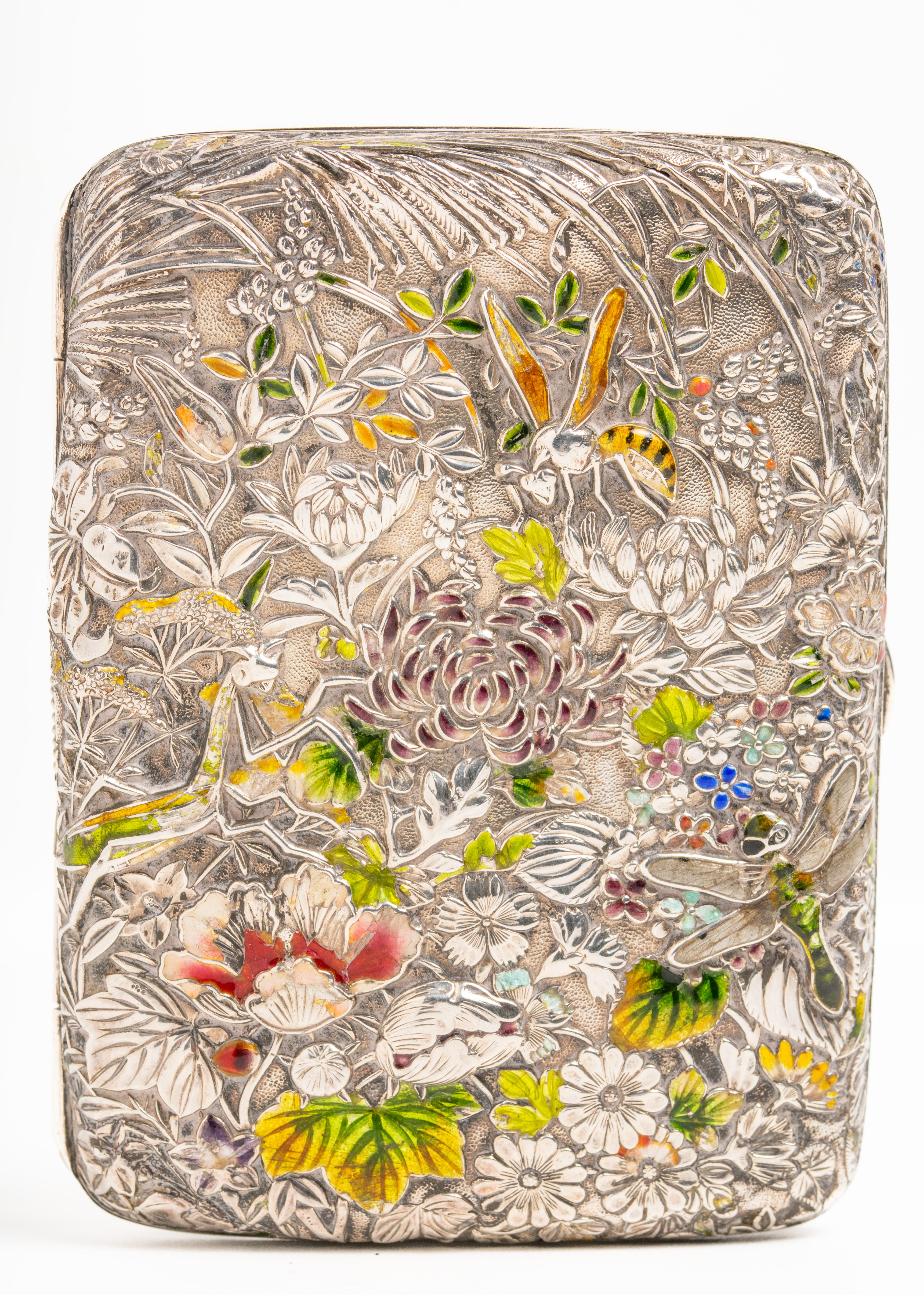 Antique 19th century Japanese Meiji period silver and enamelled silver cigarette case, circa 1890. This very rare and exquisite piece is decorated with flowers like peonies, insects; a dragonfly, a grasshopper and a bee surrounded by foliage and
