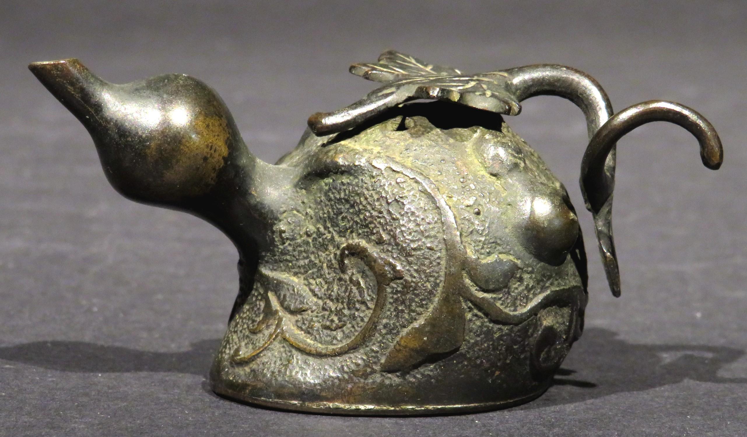 A fine 19th century scholarly object used to moisten inksticks for an inkstone when working with calligraphy. 
Naturalistically cast in the form of a gourd with a detachable leafy stem, the textured surface exhibits a fine old patina overall, the