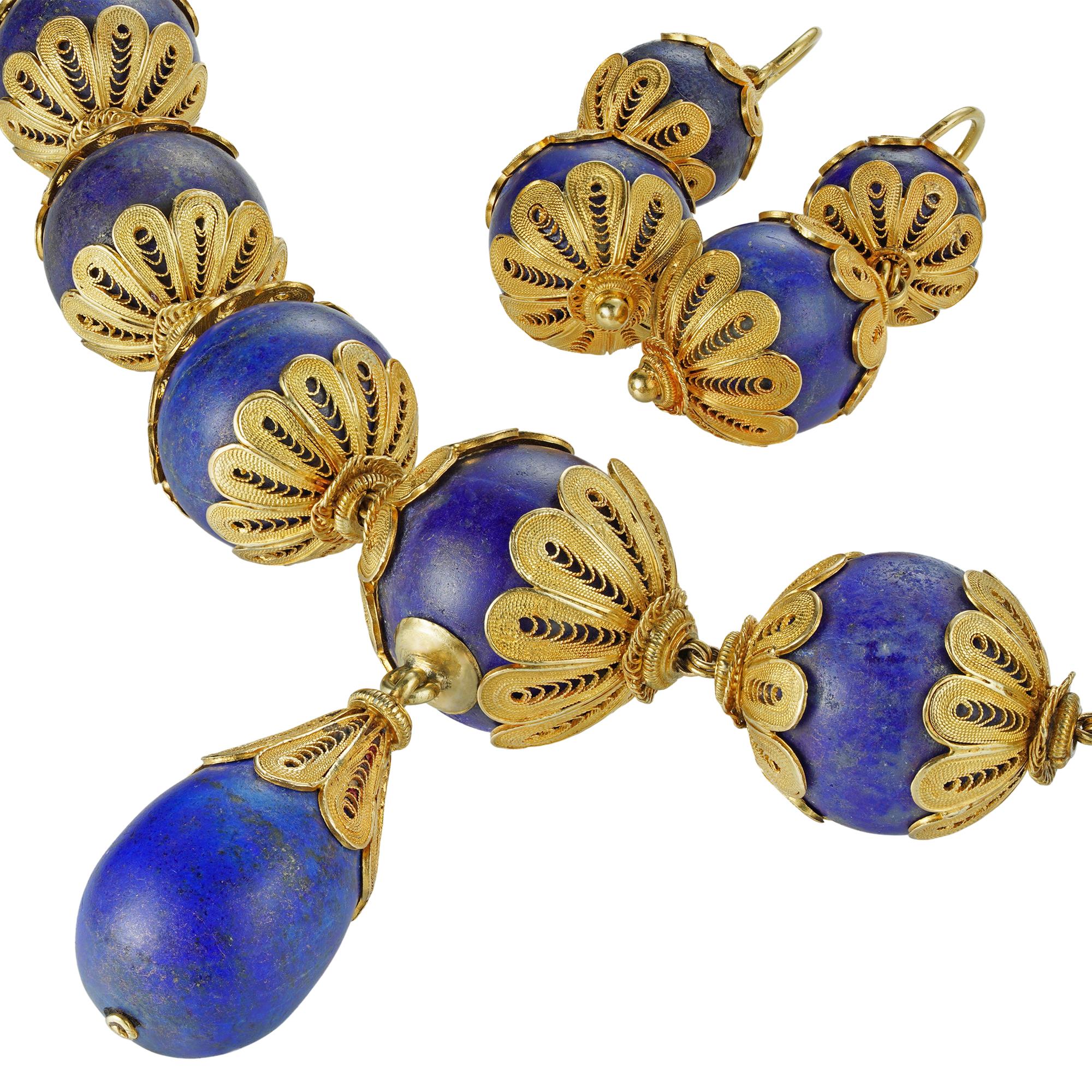A 19th Century lapis lazuli bead and gold demi-parure, the necklace consisted of twenty four graduated lapis beads measuring from 17.8mm to 13.6mm, with yellow gold filigree decorations, suspending a lapis drop with a gold filigree cap, the matching